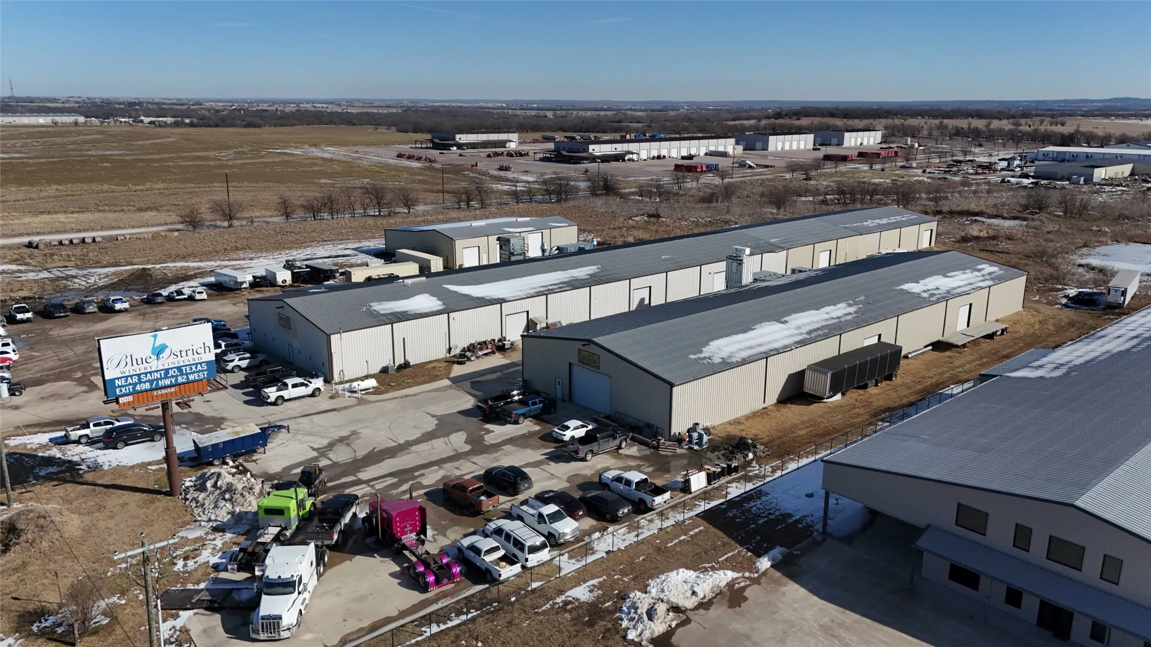 Expansive commercial property featuring multiple industrial-style buildings with metal siding and roofs
