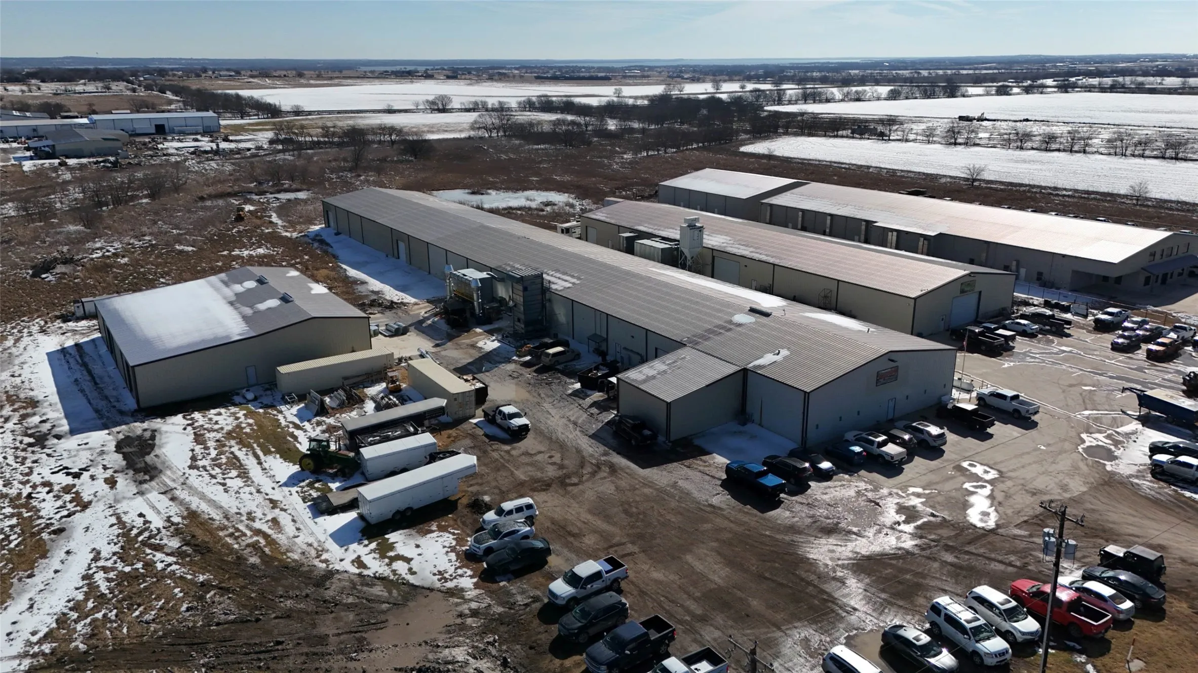 Industrial complex featuring multiple buildings with metal siding and pitched roofs
