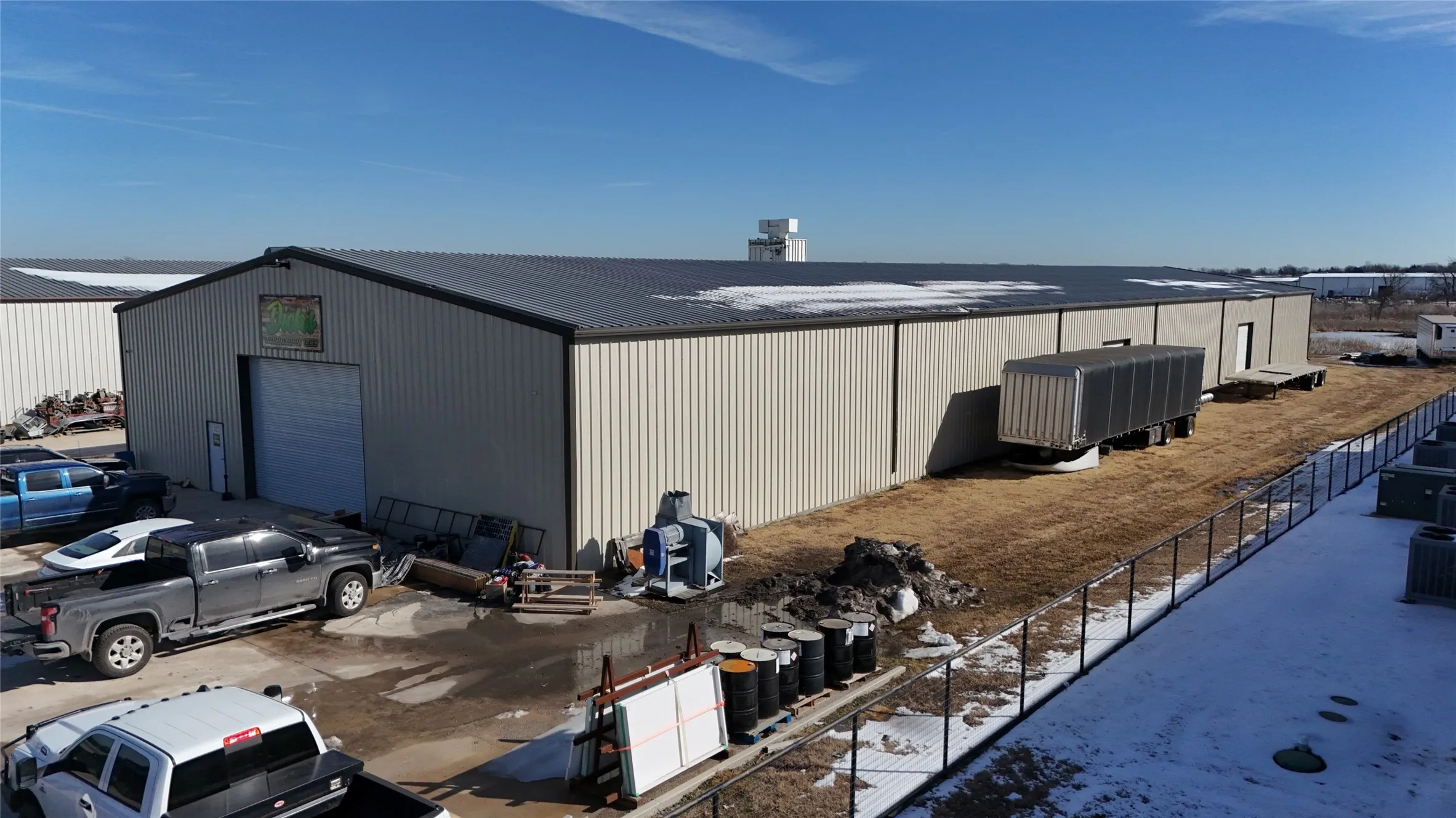 Industrial building with a tan metal exterior and dark gray gable roof