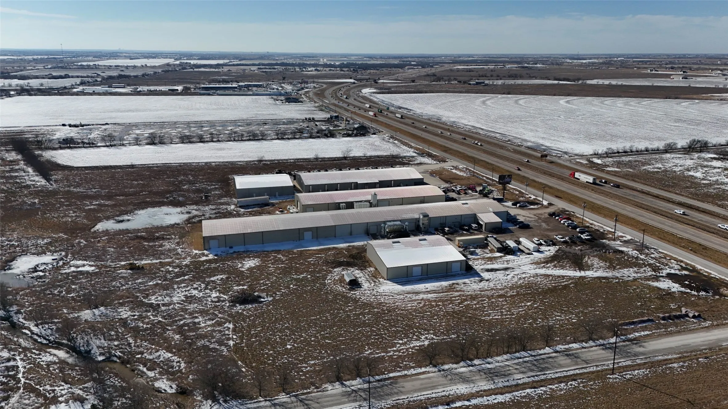 Aerial perspective showcasing multiple industrial buildings with metal roofs and roll-up doors