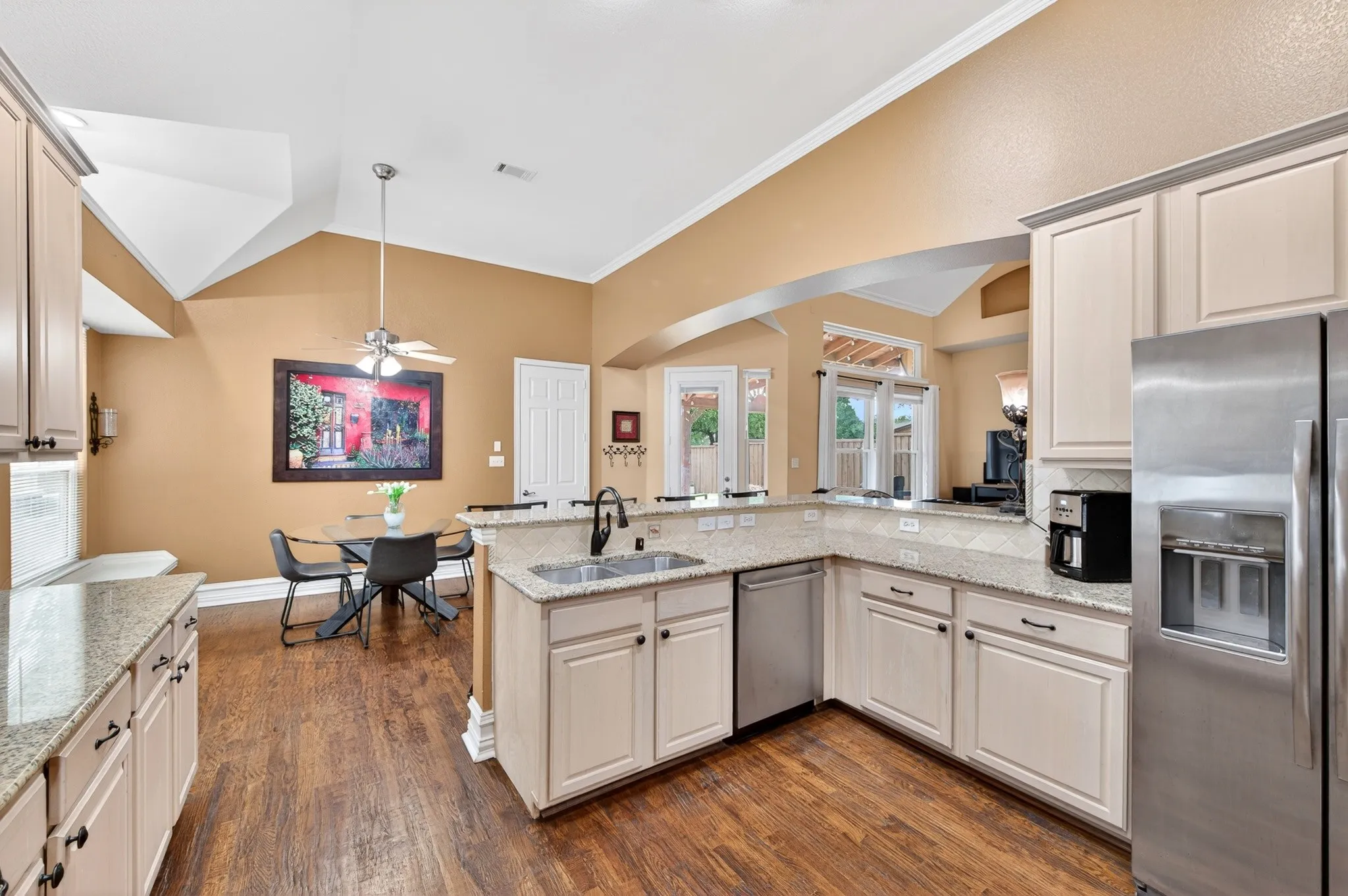 Kitchen featuring light-toned cabinetry, granite countertops, and wood-finish flooring
