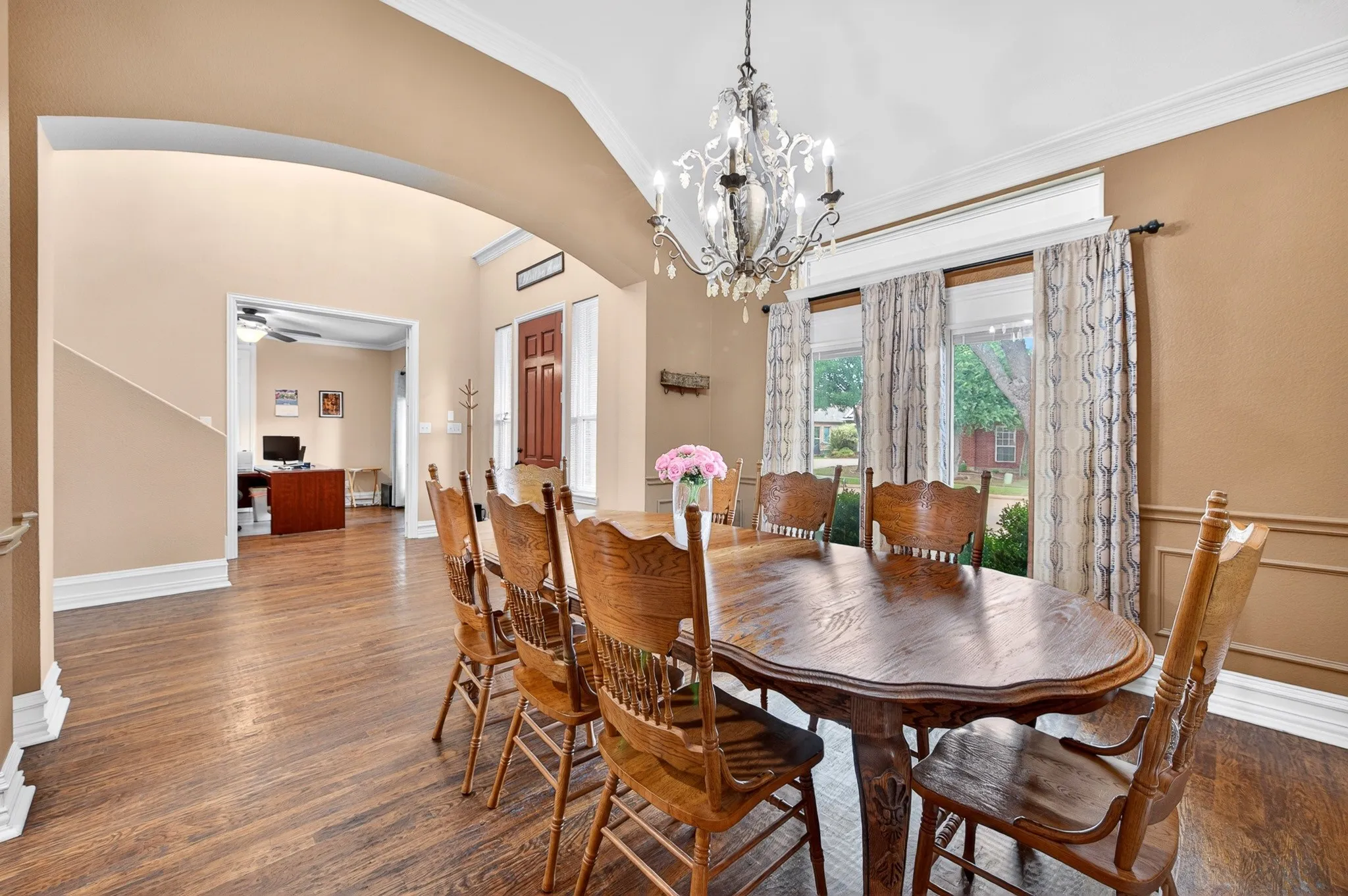 Formal dining area featuring rich wood-finish flooring and an ornate chandelier
