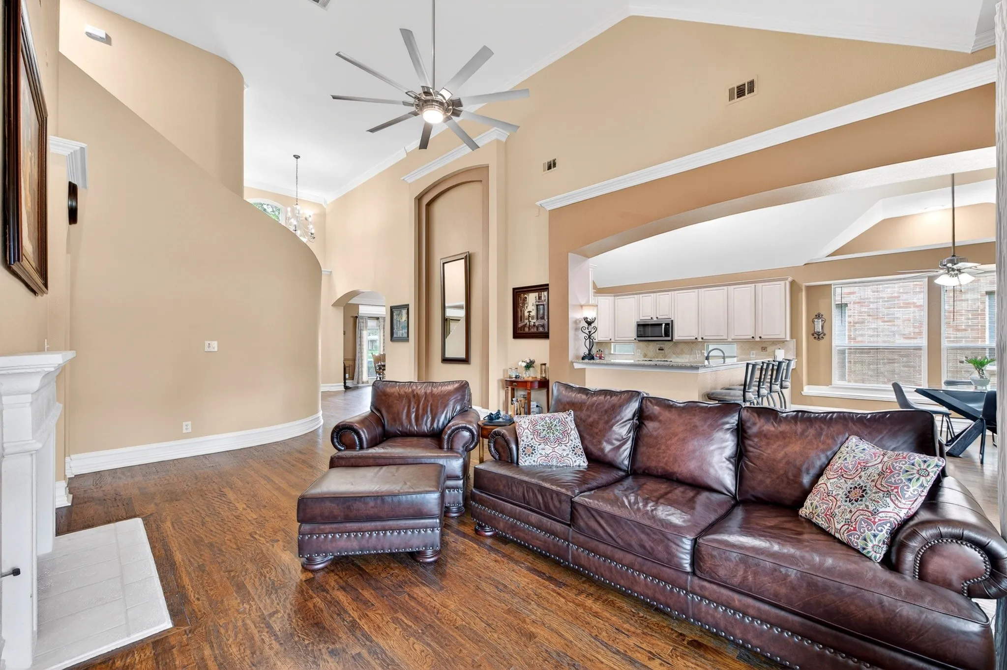 Expansive living space featuring wood-finish flooring and a white mantelpiece