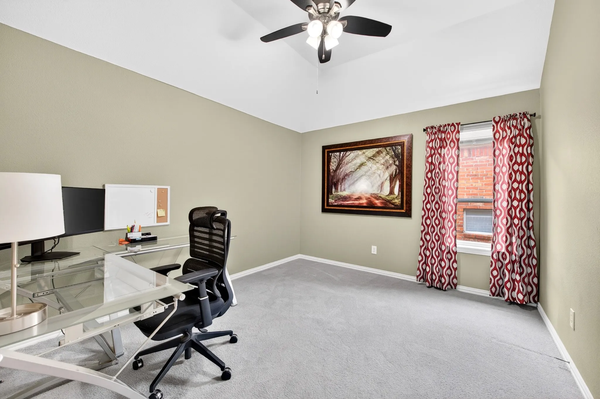 Second floor bedroom featuring a vaulted ceiling with a ceiling fan, neutral wall tones, and a window with patterned curtains