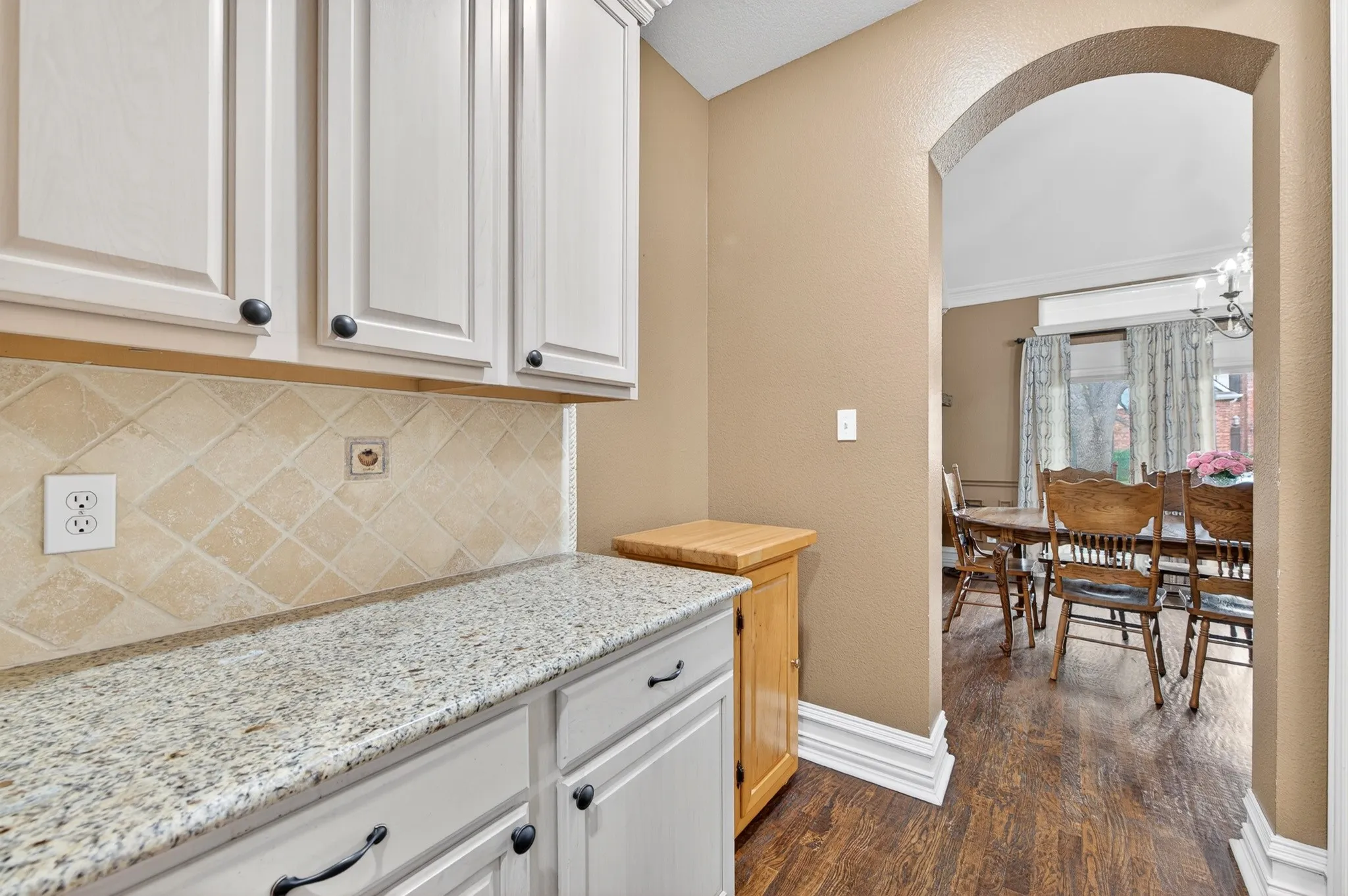 Beautiful Butlers Pantry with granite countertops, and a tiled backsplash