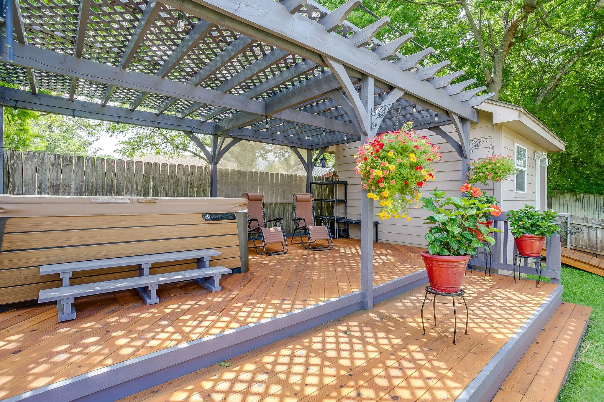 Raised patio with hot tub and pergola.