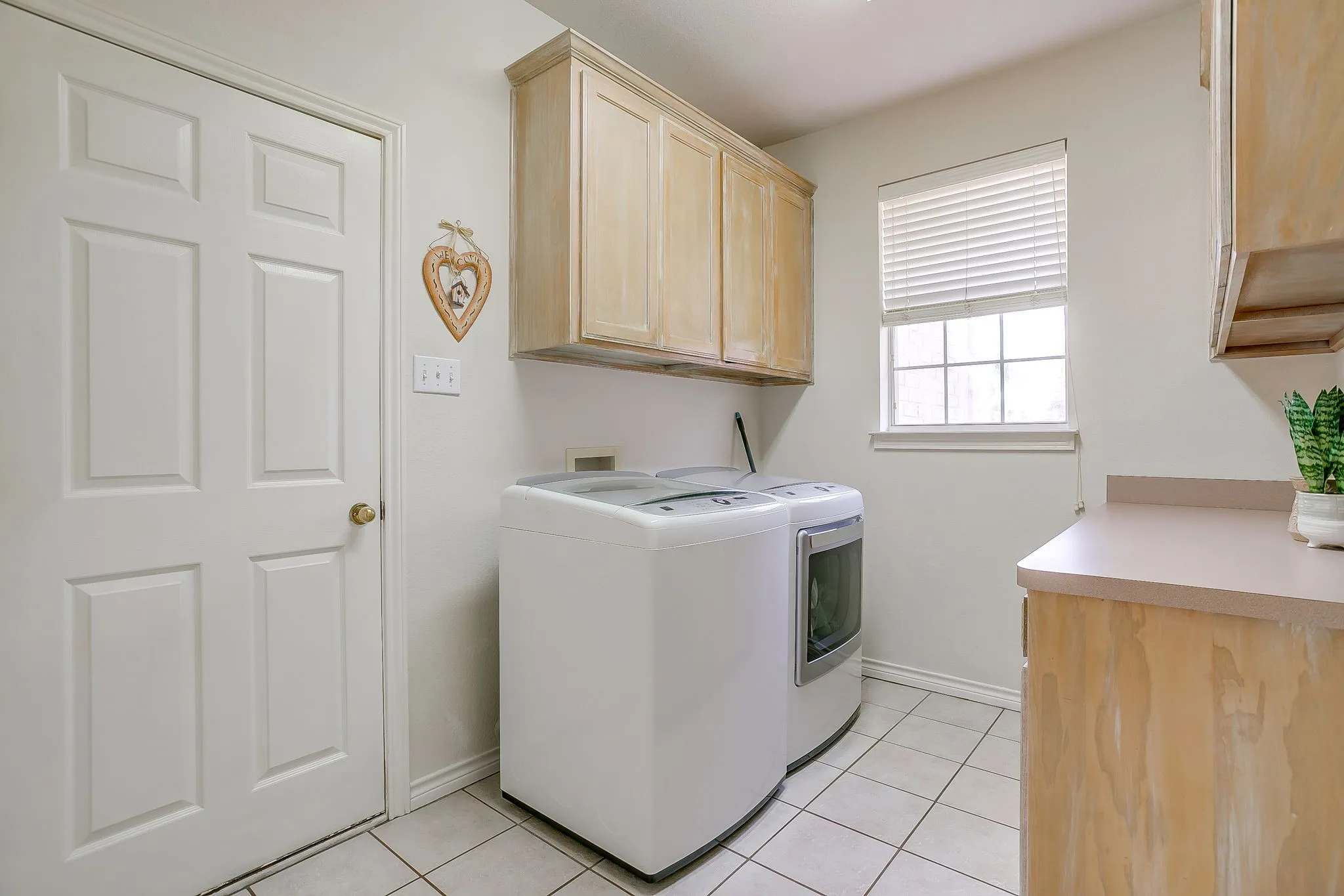 Sizeable laundry room with storage.