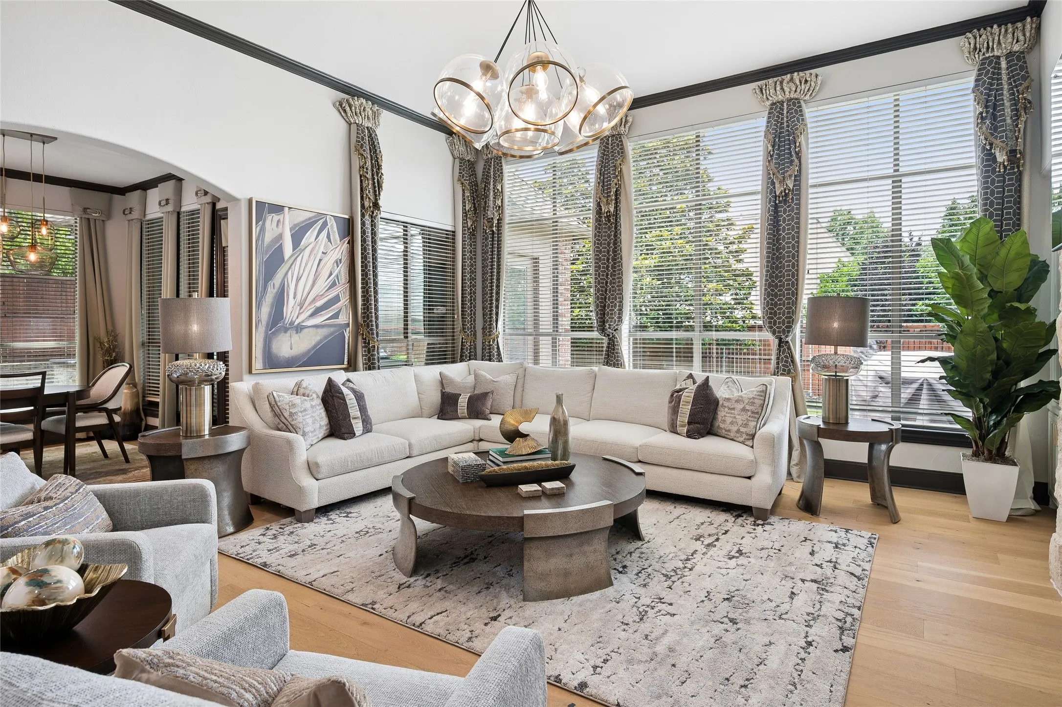 Natural light flows through the Living Room accented with custom drapery and modern lighting