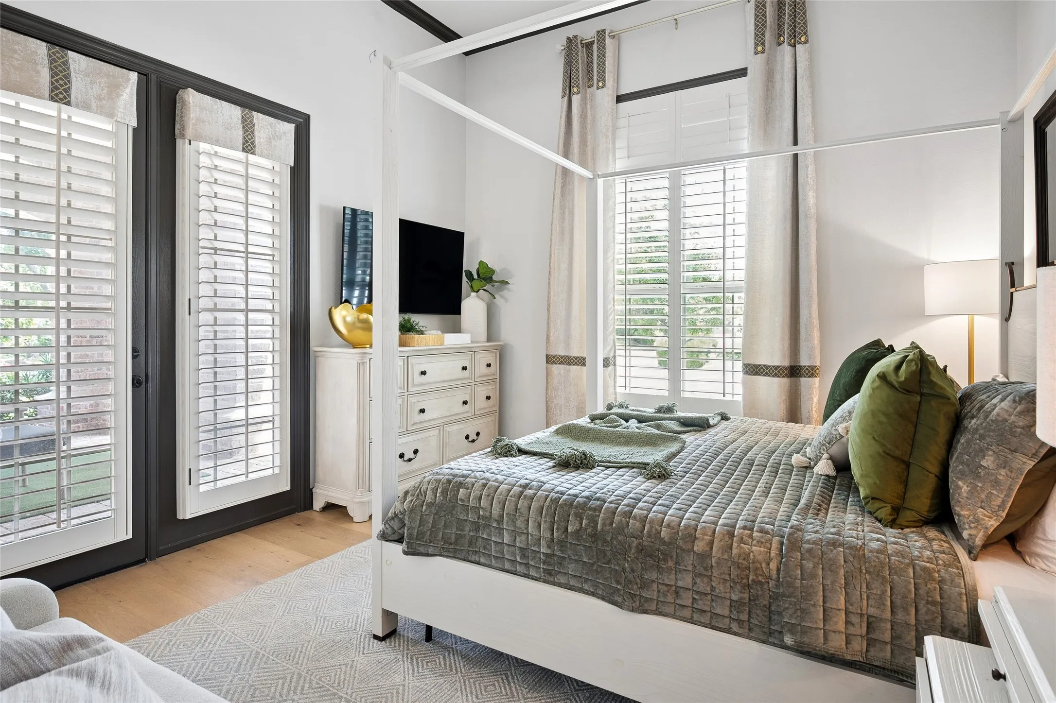 Guest suite downstairs with door to patio and an en-suite bath. Pretty Plantation shutters.