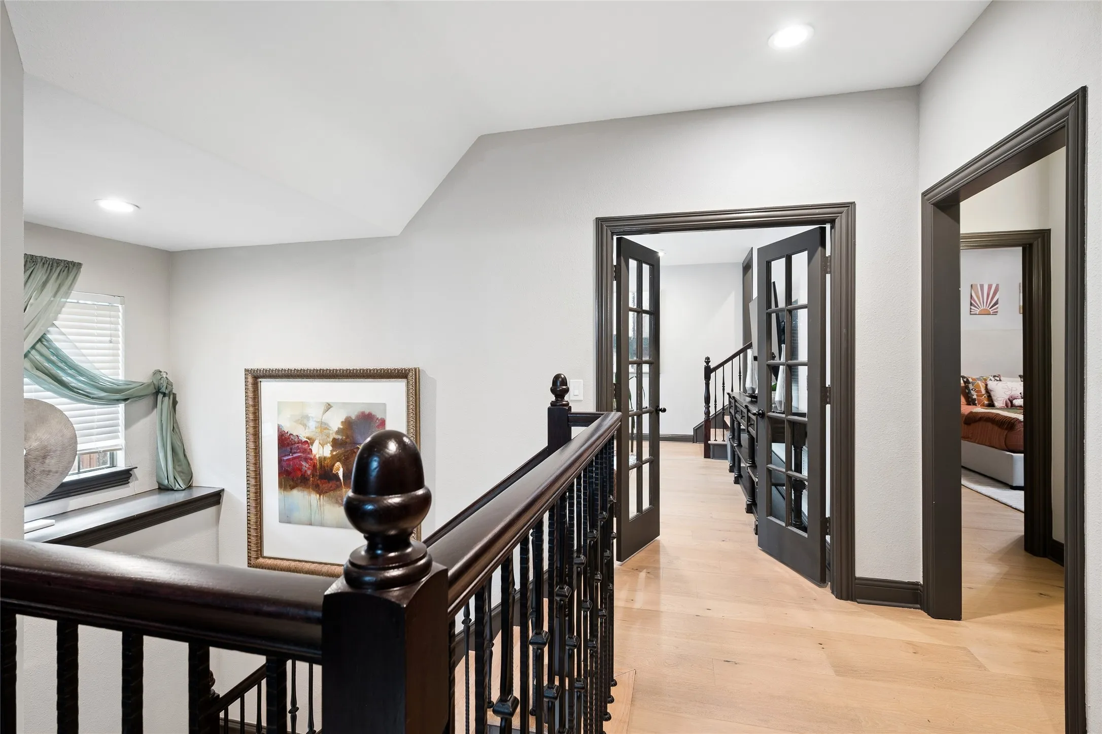 Upstairs view of French doors to the game room and media room. Note wood floors upstairs too.