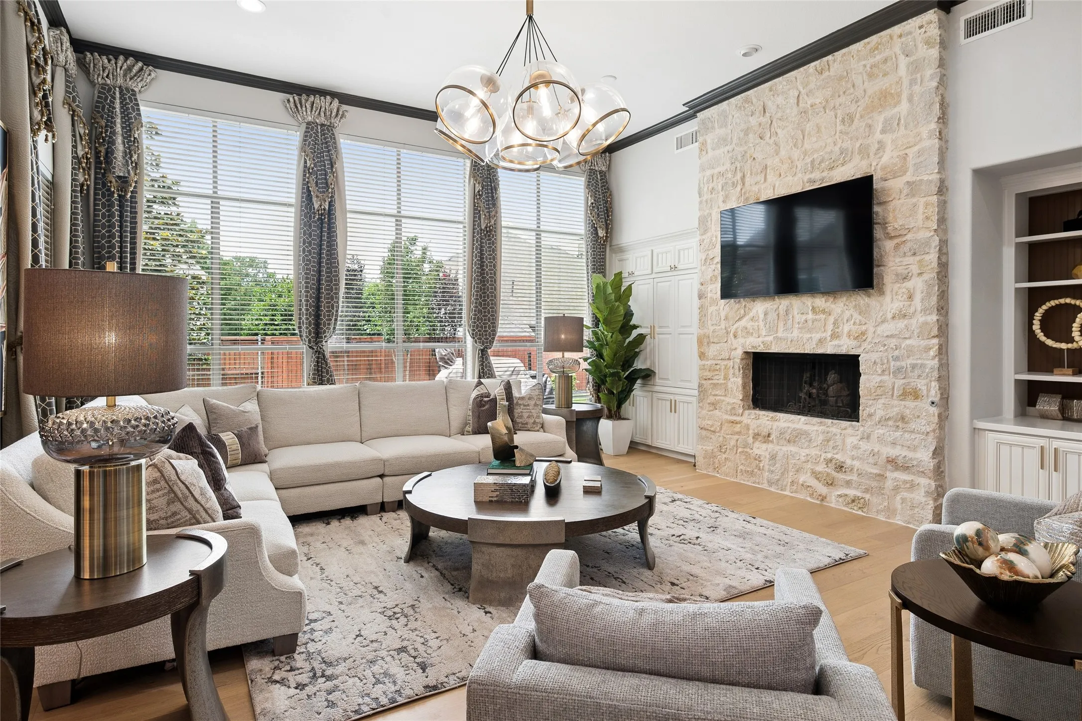 Fireplace wall of stone flanked by a hidden dry bar and built-ins