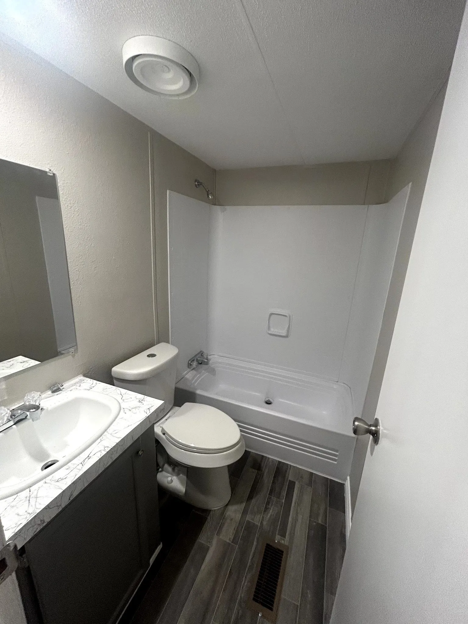 Contemporary bathroom featuring a dark wood-finish vanity with a white countertop and integrated sink