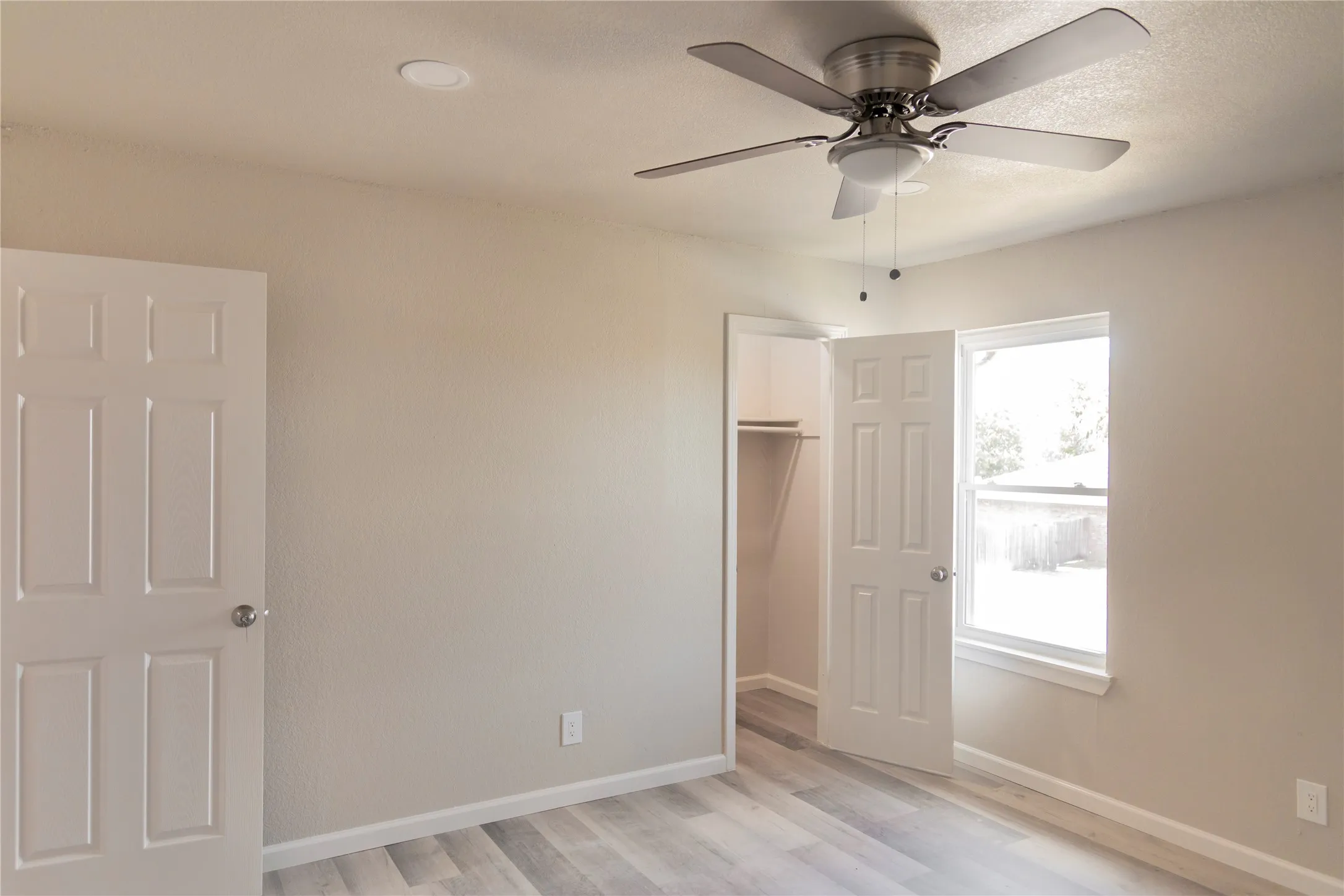 Interior room featuring wood-finish flooring, neutral wall paint, and white trim