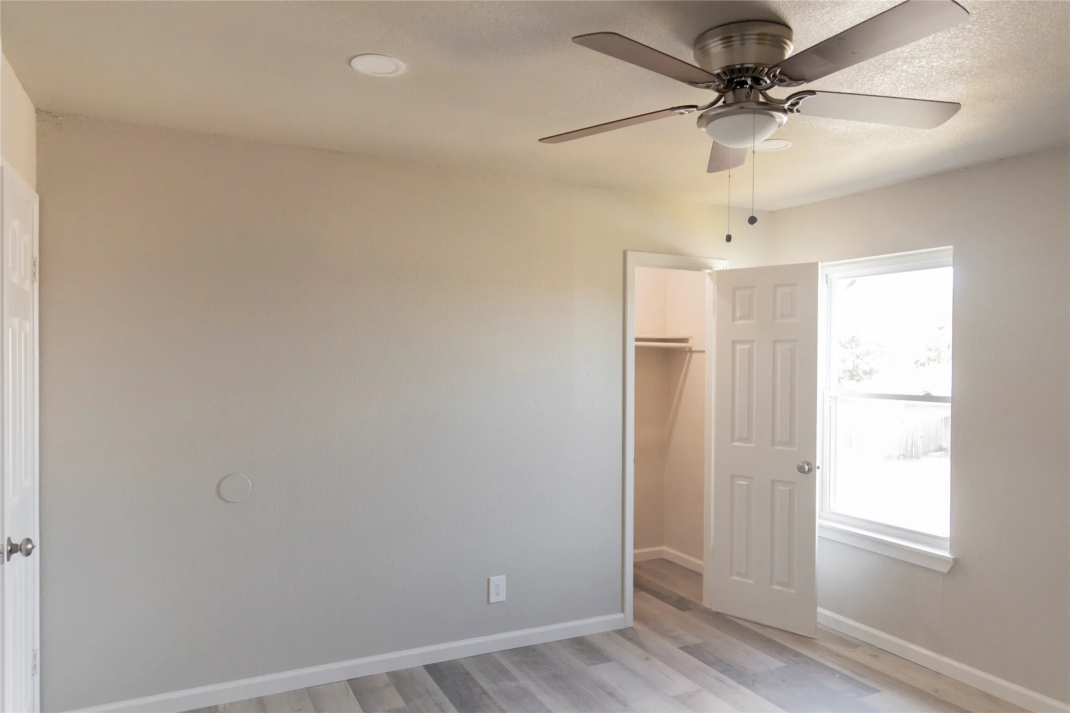 Neutral tone walls complement the wood-finish flooring