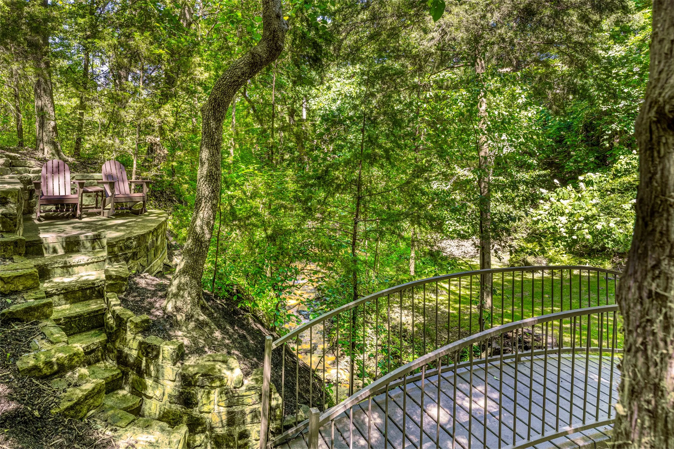 Natural setting on property with a footbridge taking you to a sitting area.