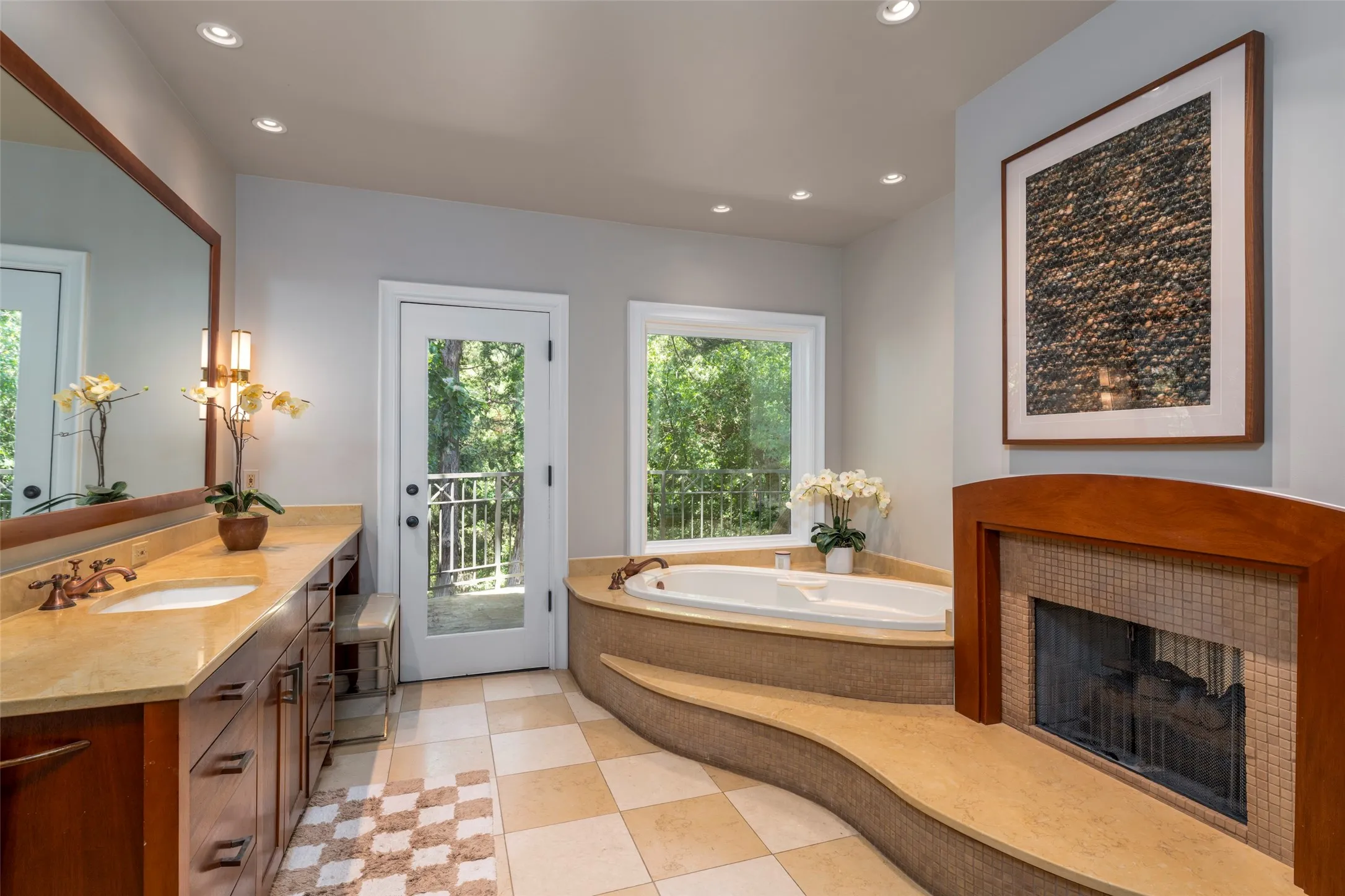Escape to tranquility in this beautifully appointed
primary bath featuring heated Travertine floors,
marble countertops, garden tub and steam shower.