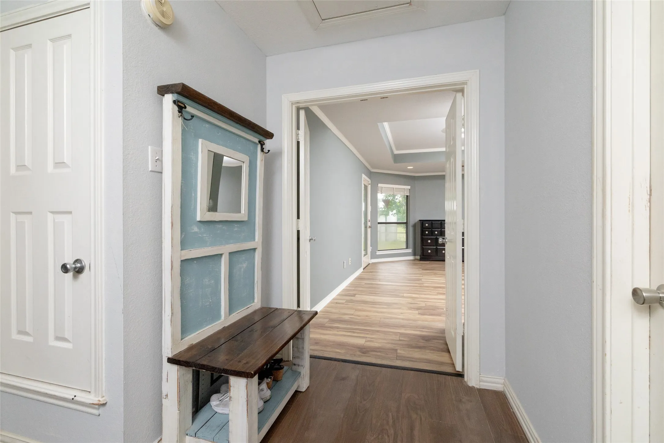 Interior hallway with light gray walls and wood-look flooring