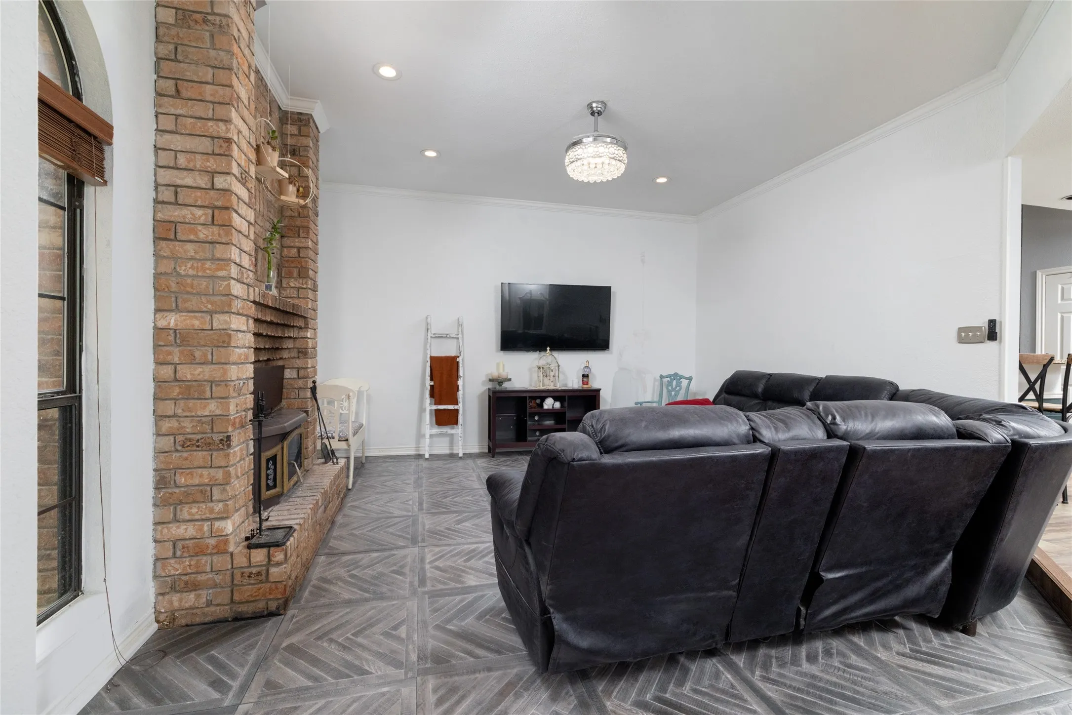 Living area featuring brick fireplace with hearth, patterned tile flooring