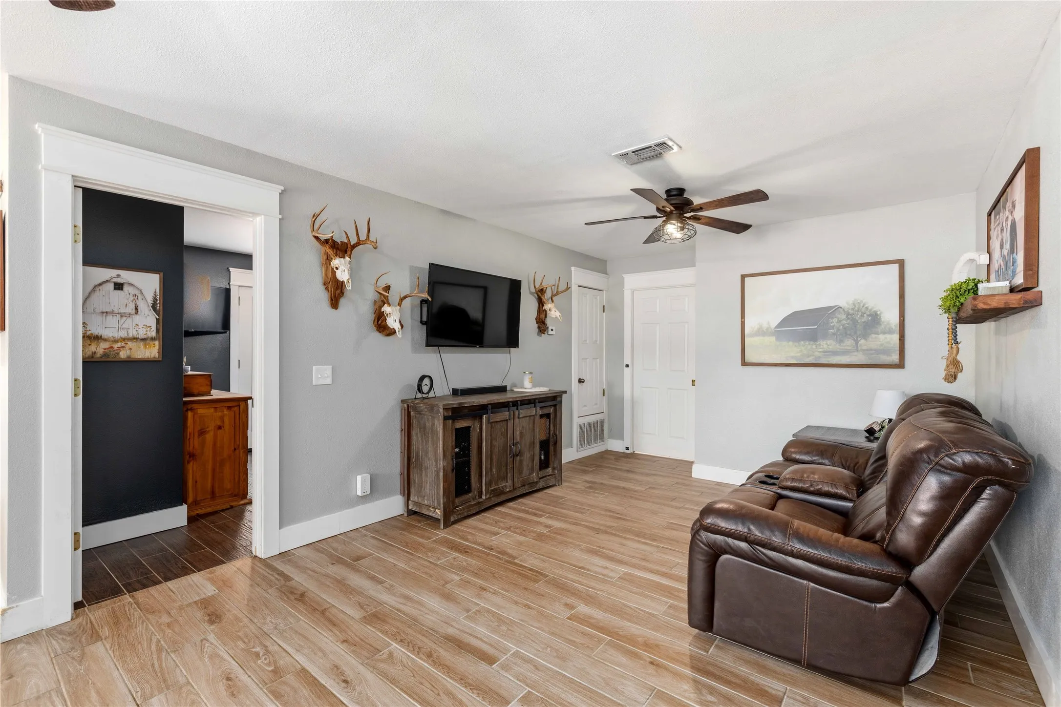 Expansive room featuring wood-finish flooring, light grey walls, and white trim