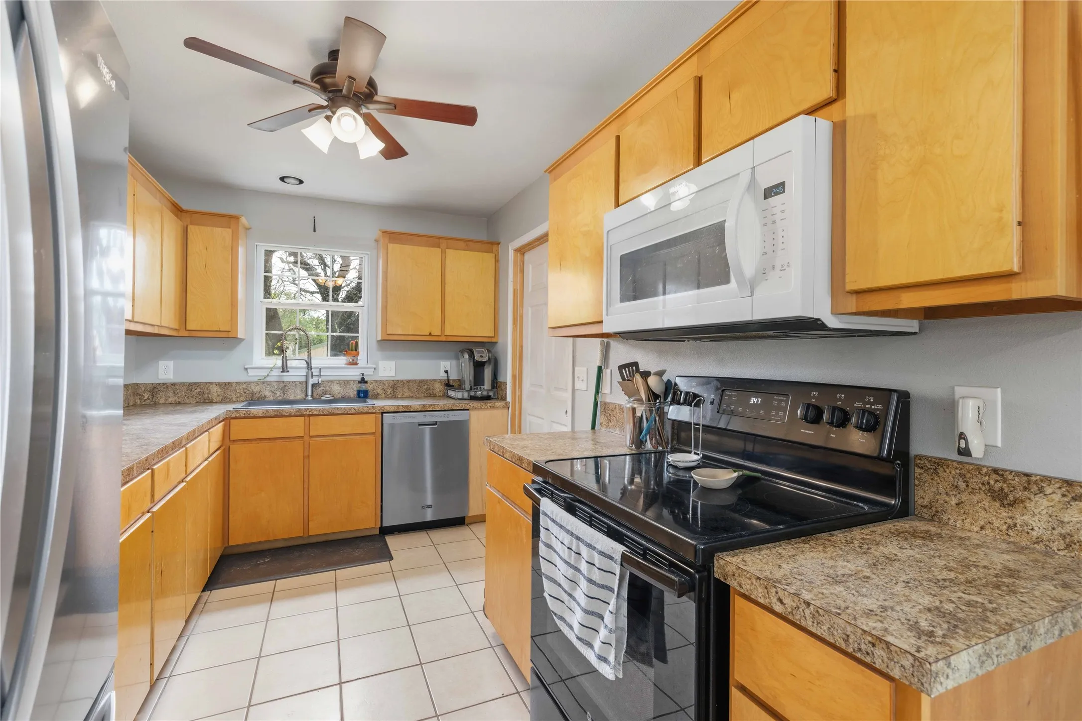 Kitchen featuring light wood cabinetry and speckled countertops