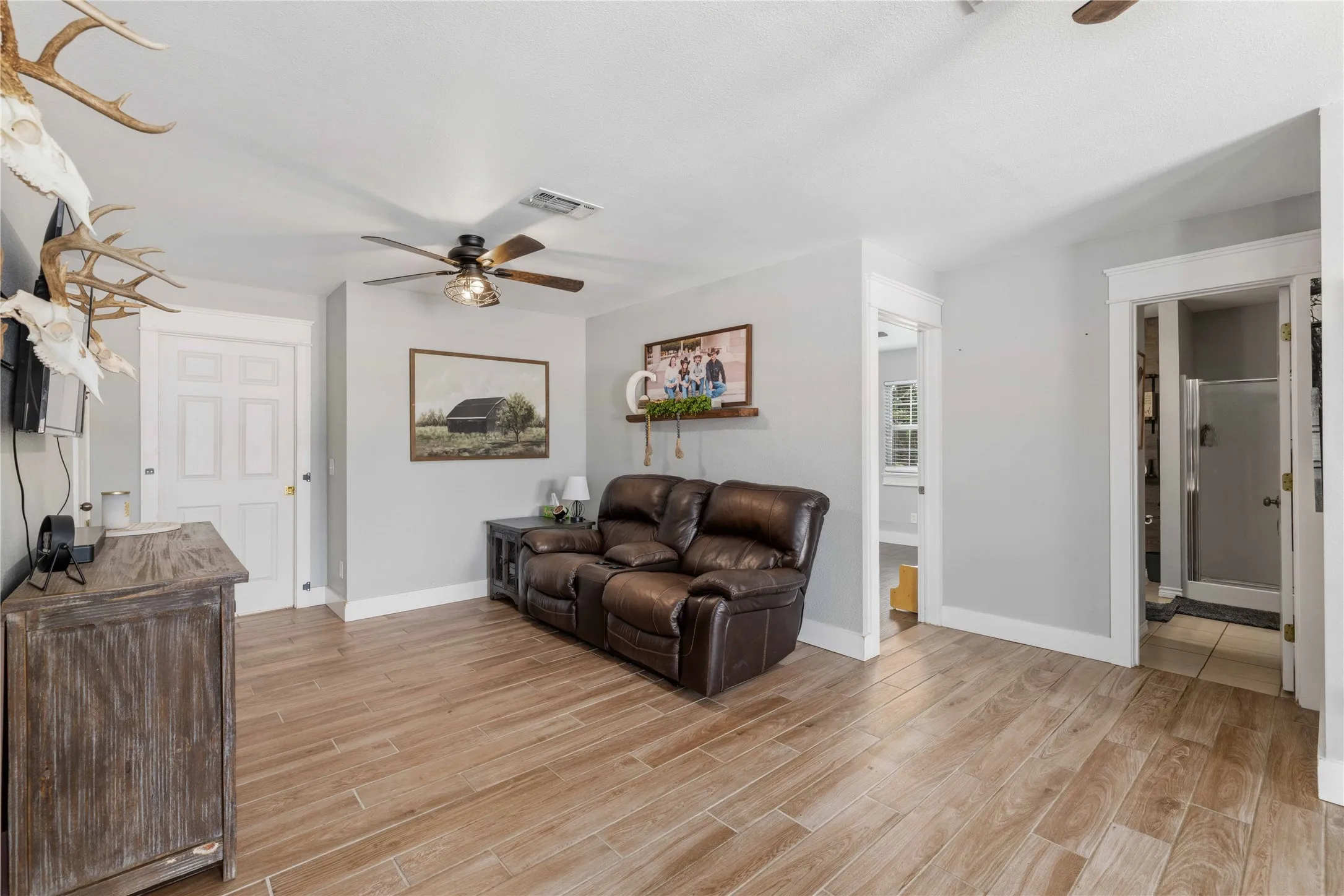 Living area featuring wood-finish flooring, light gray walls, and white trim