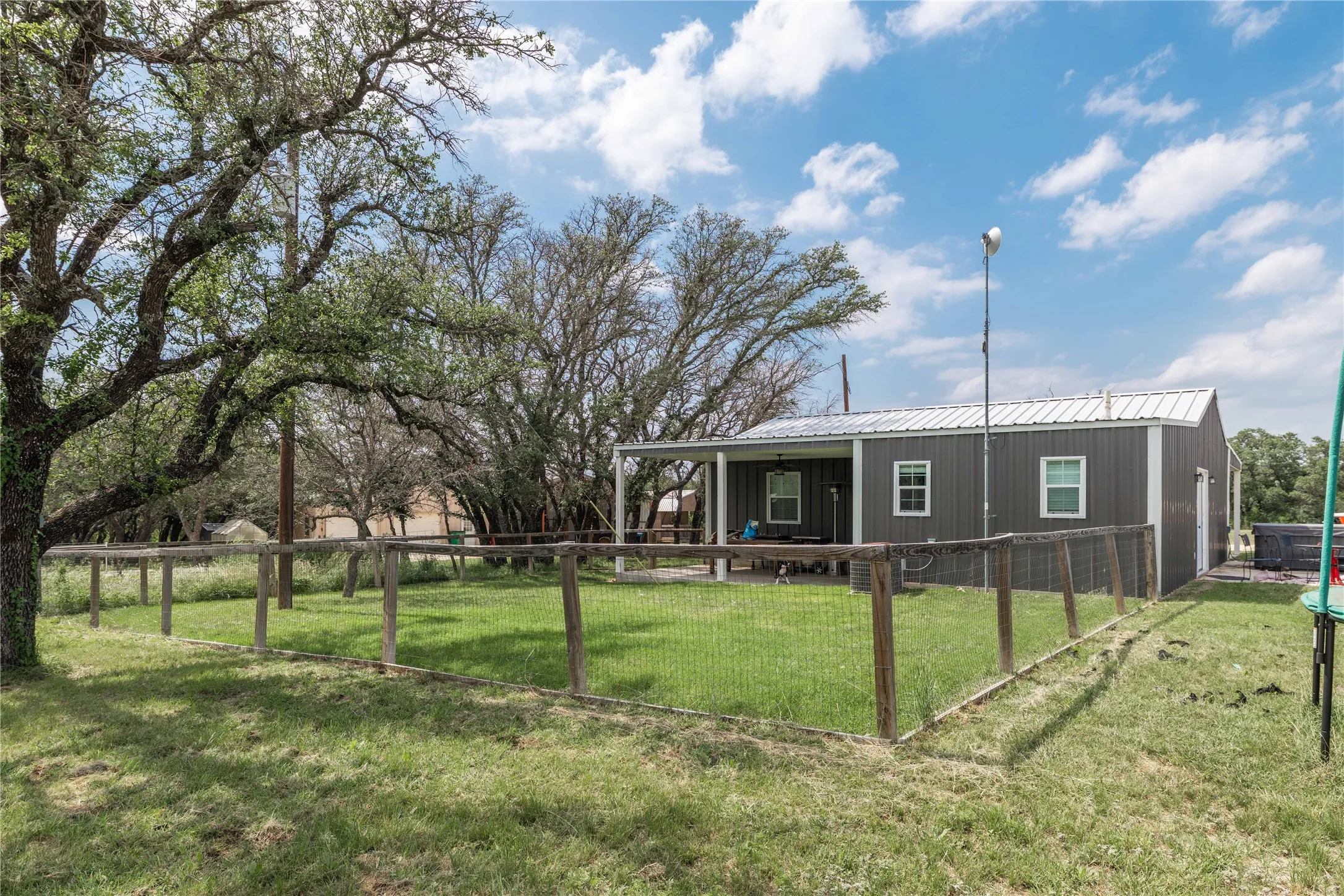 Fenced yard with mature trees providing ample shade