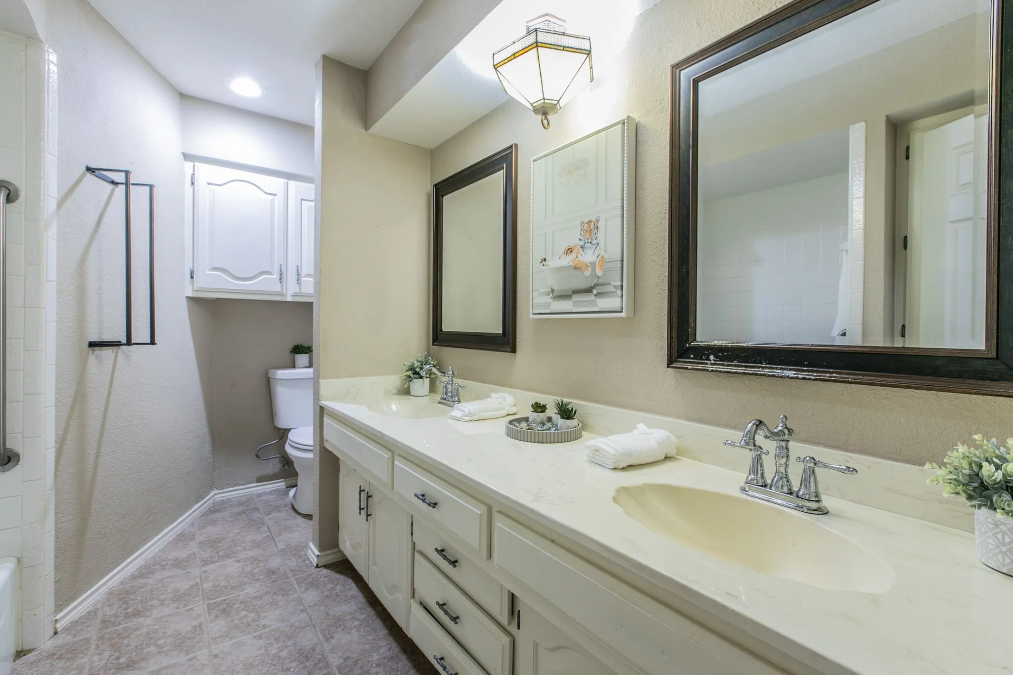 Bathroom featuring a double vanity with light-toned countertops and integrated sinks