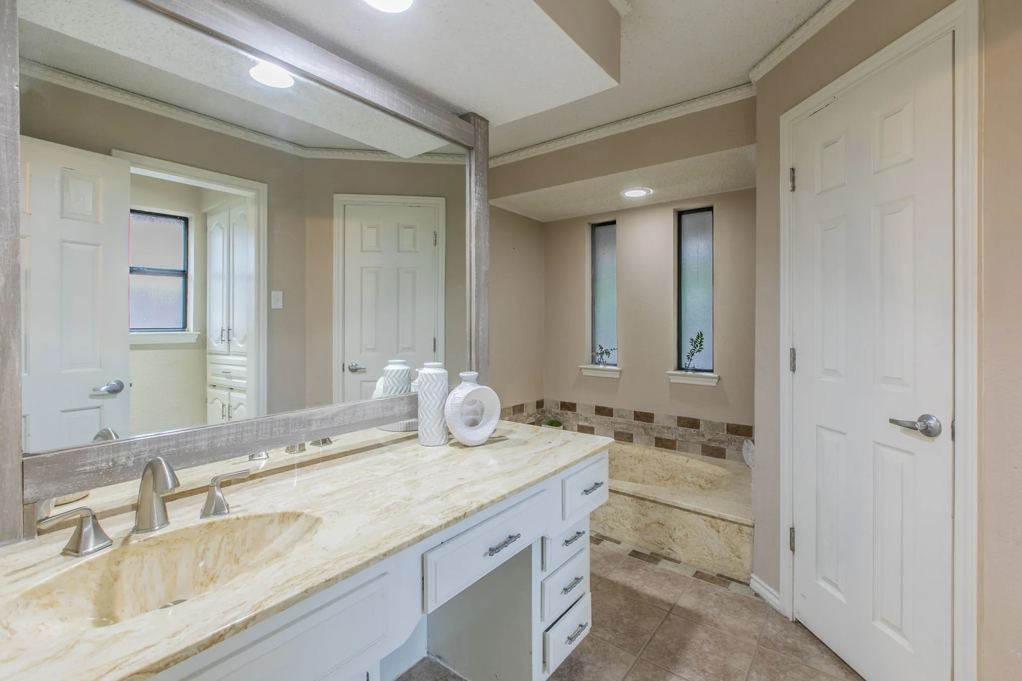 Dual sink vanity featuring a light-toned countertop with integrated bowl sinks and brushed nickel fixtures