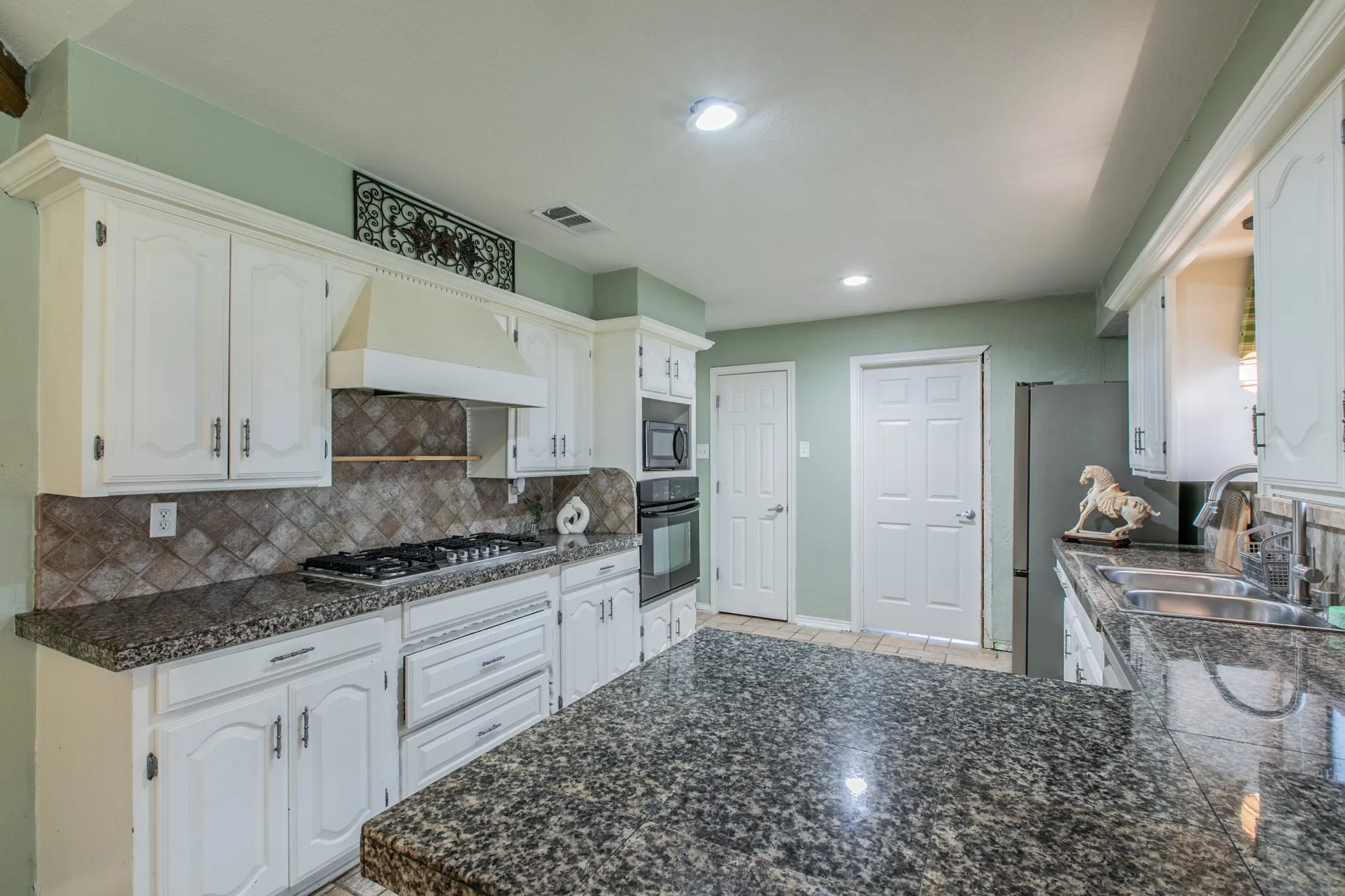 Kitchen featuring white cabinetry, granite countertops, a built-in gas range, a tile backsplash, and recessed lighting