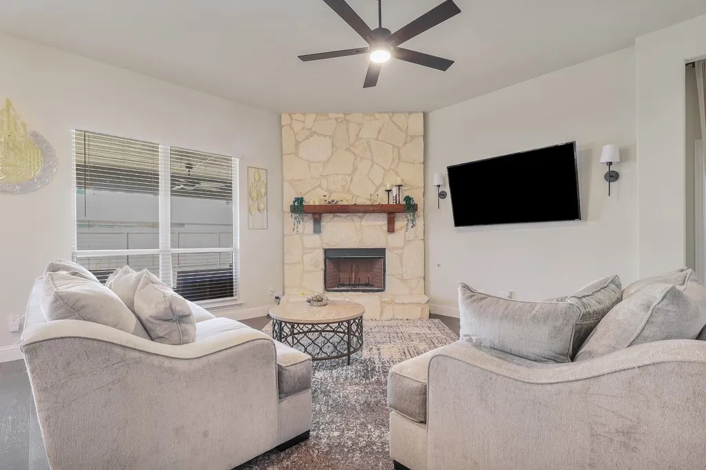 Living room featuring ceiling fan and a fireplace