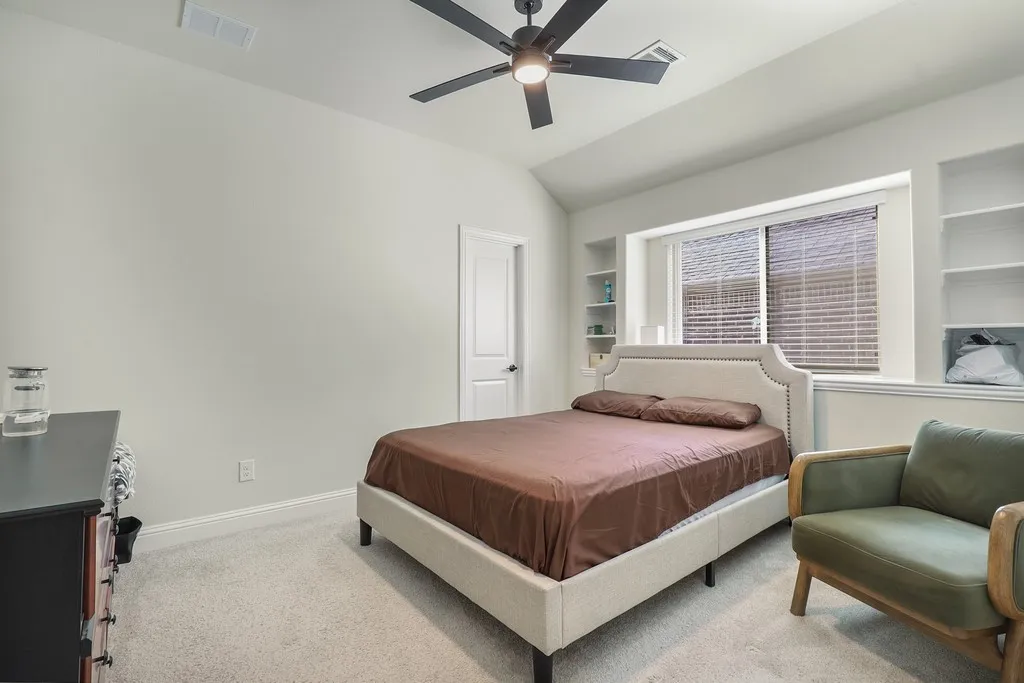 Bedroom with light carpet, a ceiling fan, and lofted ceiling