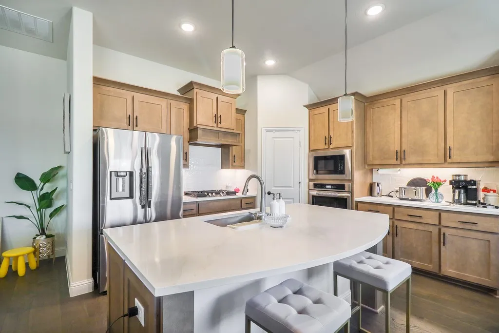 Kitchen featuring a breakfast bar, dark wood finished floors, tasteful backsplash, and stainless steel appliances