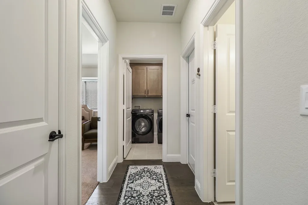 Laundry area with cabinet space, washer and dryer, and dark wood finished floors