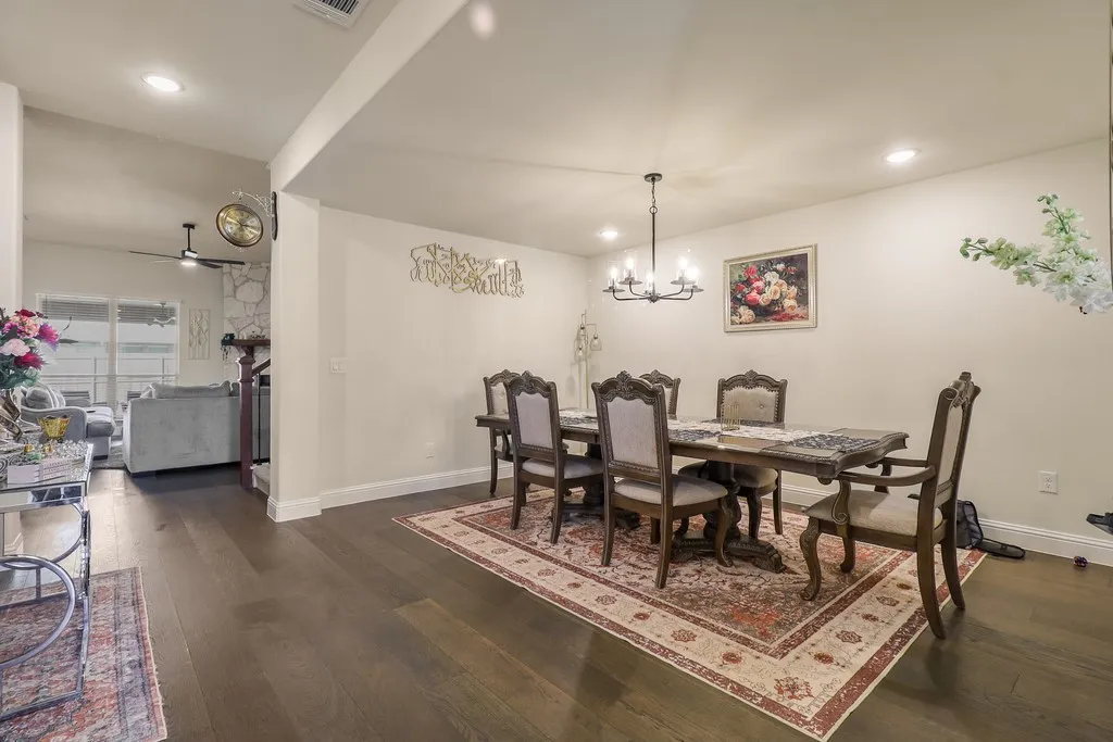Dining room with dark wood-style flooring, a ceiling fan, and suspended lighting