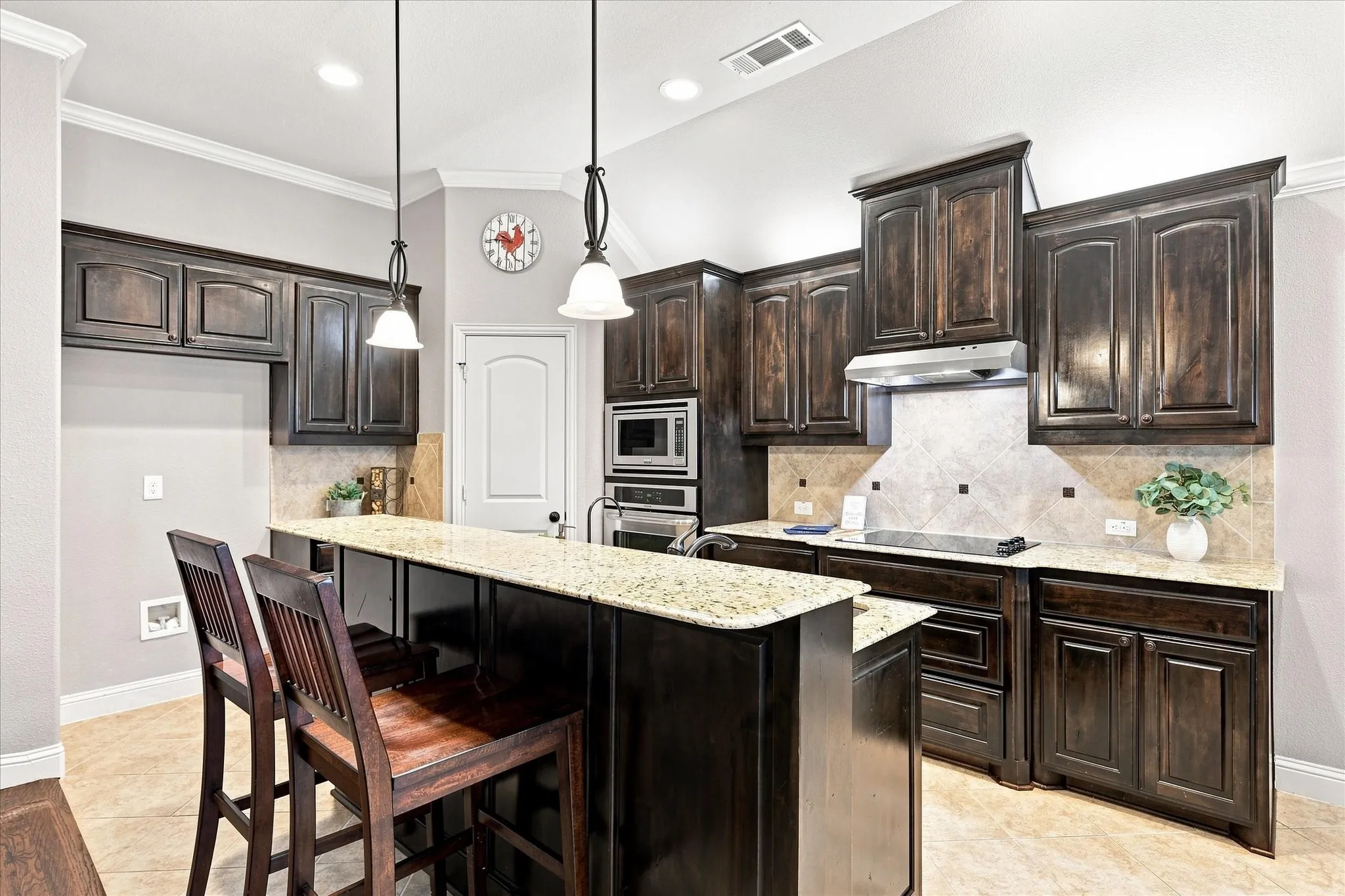 Kitchen featuring rich wood cabinetry, light-toned countertops, and a tile backsplash