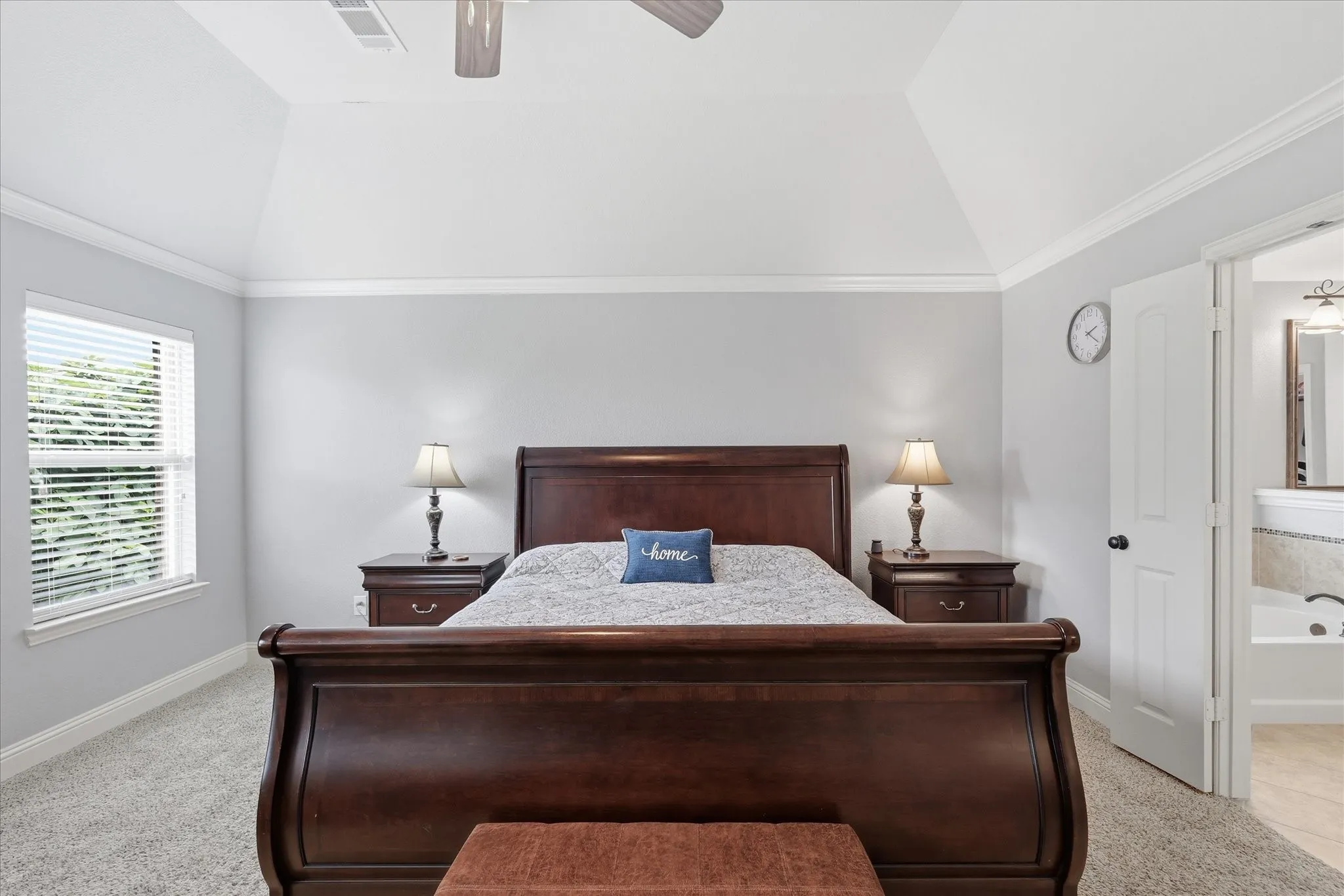 Carpeted room featuring a vaulted ceiling and crown molding
