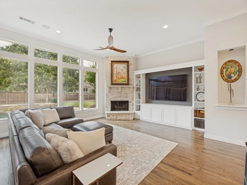 Family room with double-stacked stone fireplace and TV built-in with storage.