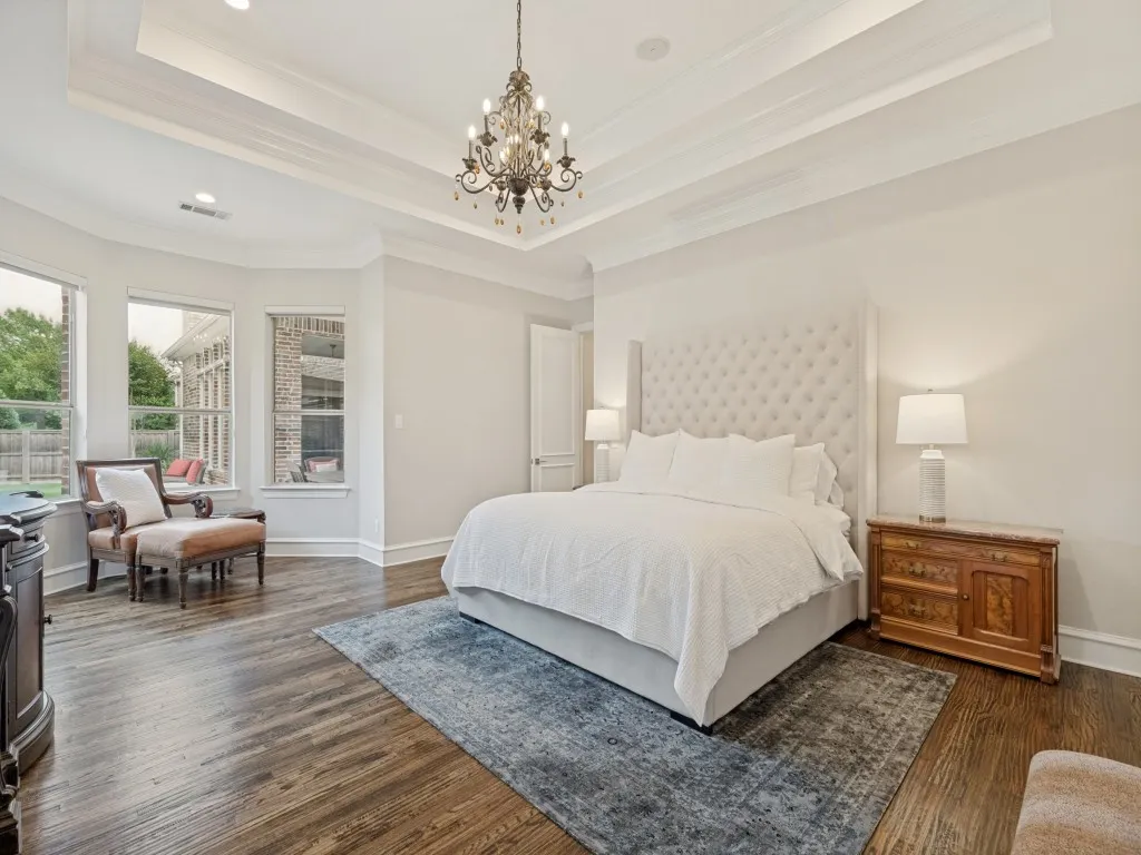 Primary suite with trayed lighted ceiling and sitting area.
