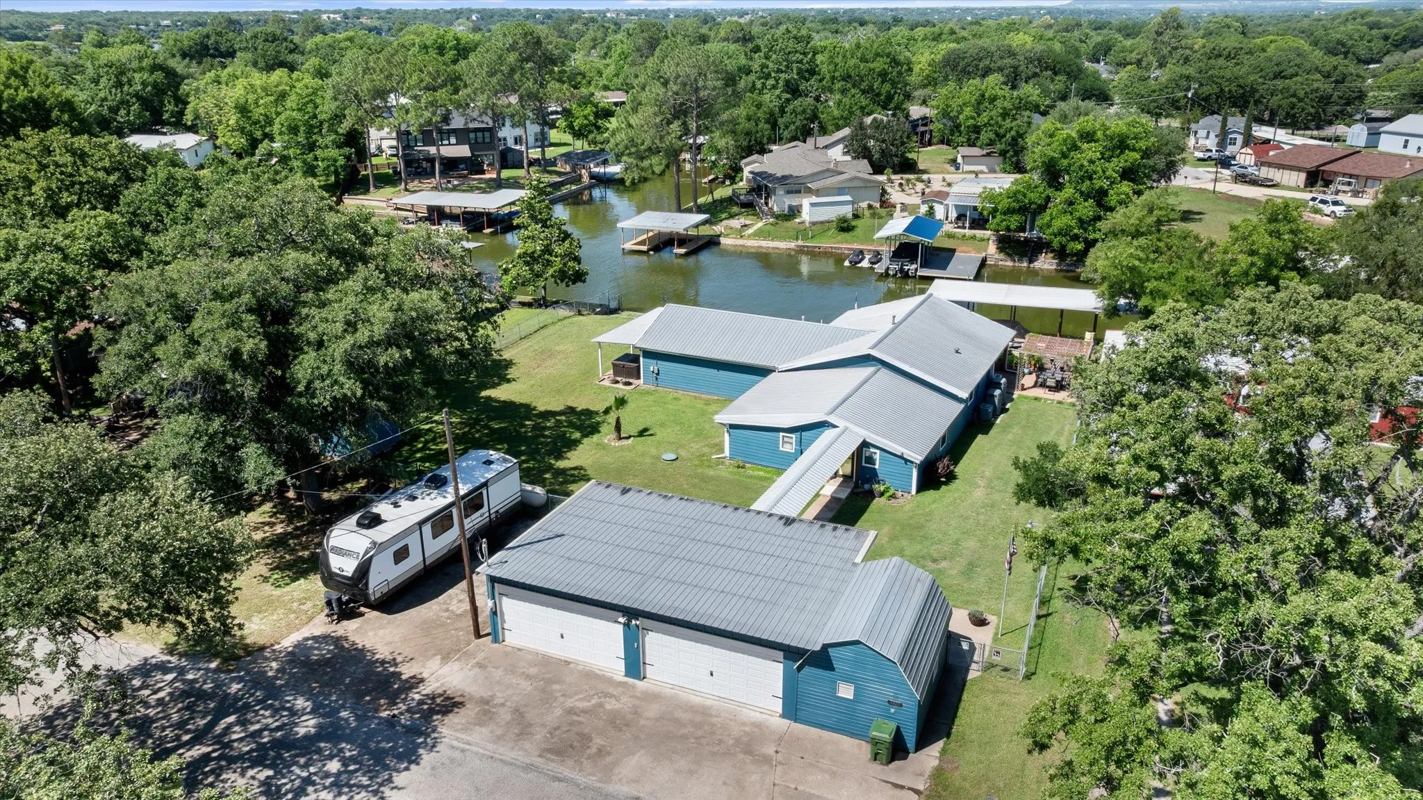 Waterfront property featuring a blue exterior, metal roofing, and multiple boat docks