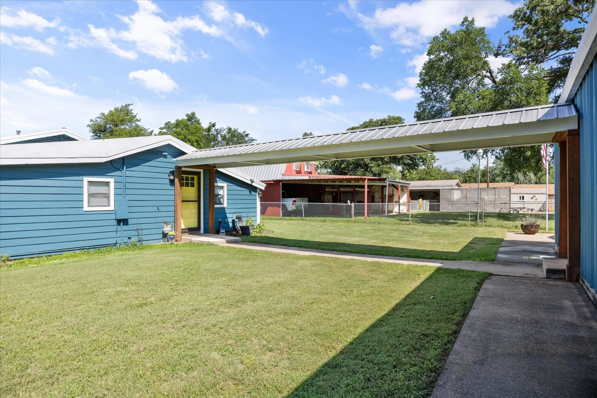 Expansive grass yard with a covered walkway connecting structures