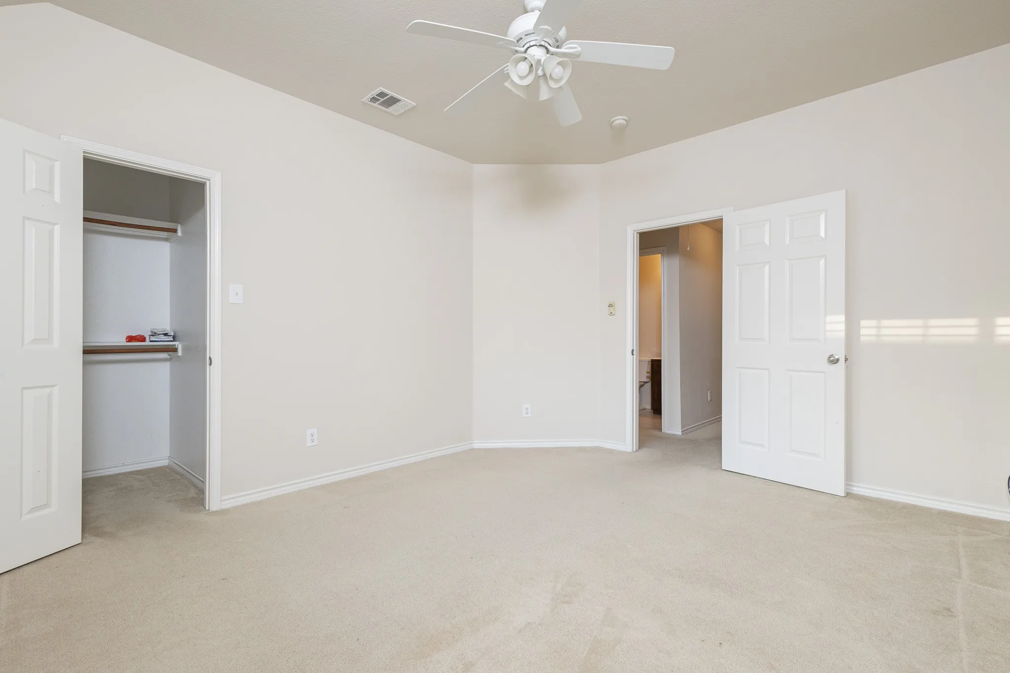 Unfurnished bedroom with light carpet, a closet, and ceiling fan