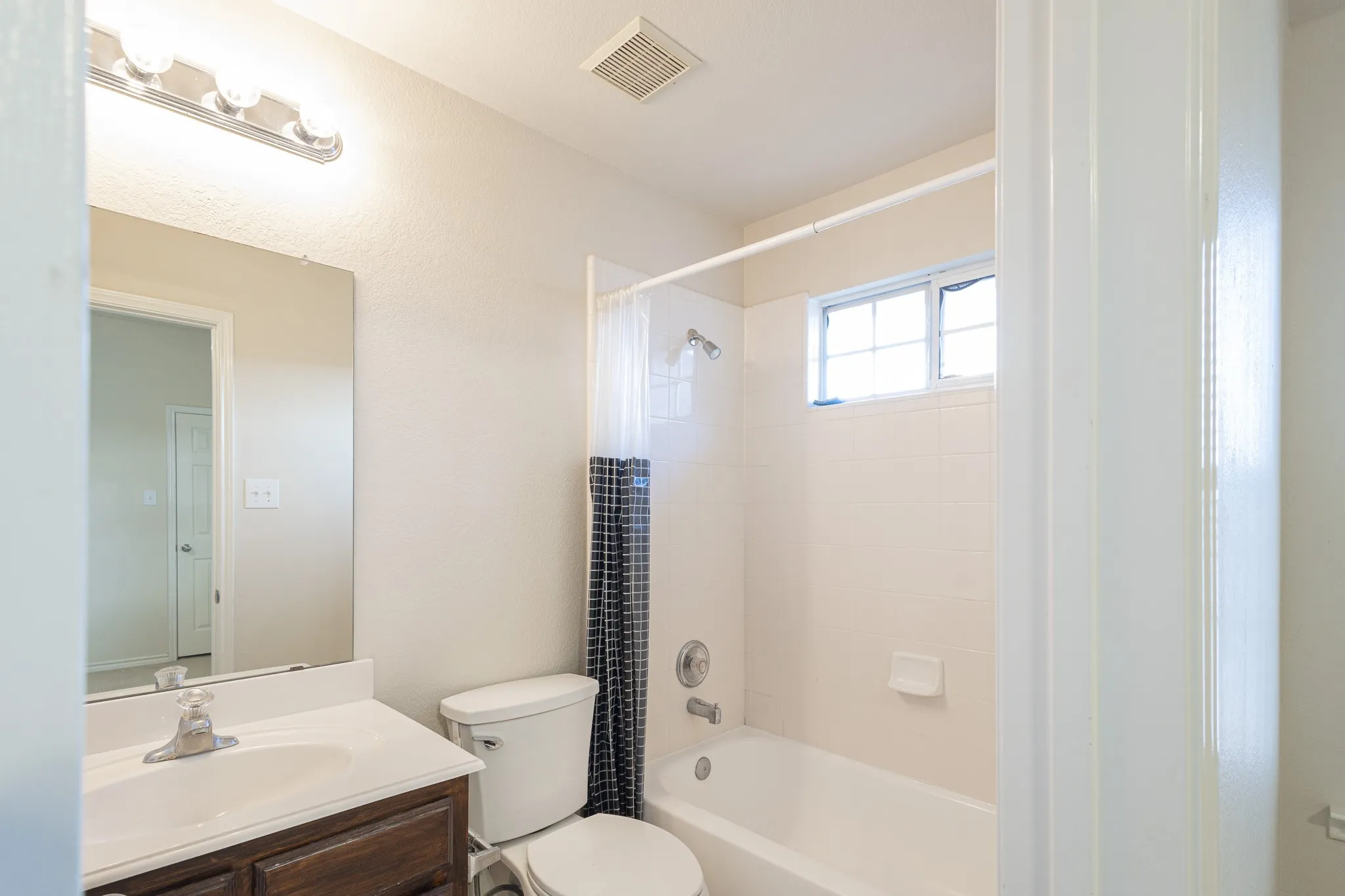 Full bathroom featuring tiled shower / bath, vanity, and toilet