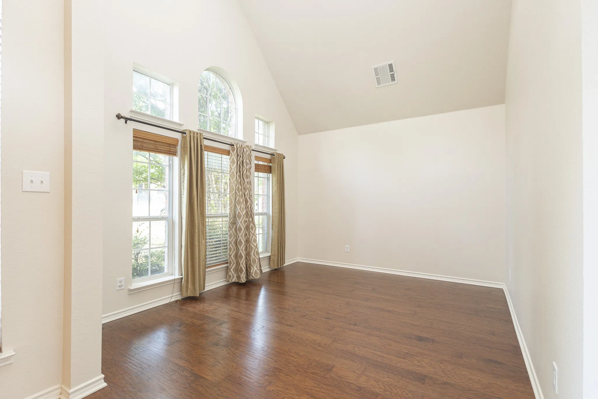 Foyer featuring high vaulted ceiling and dark wood-type flooring