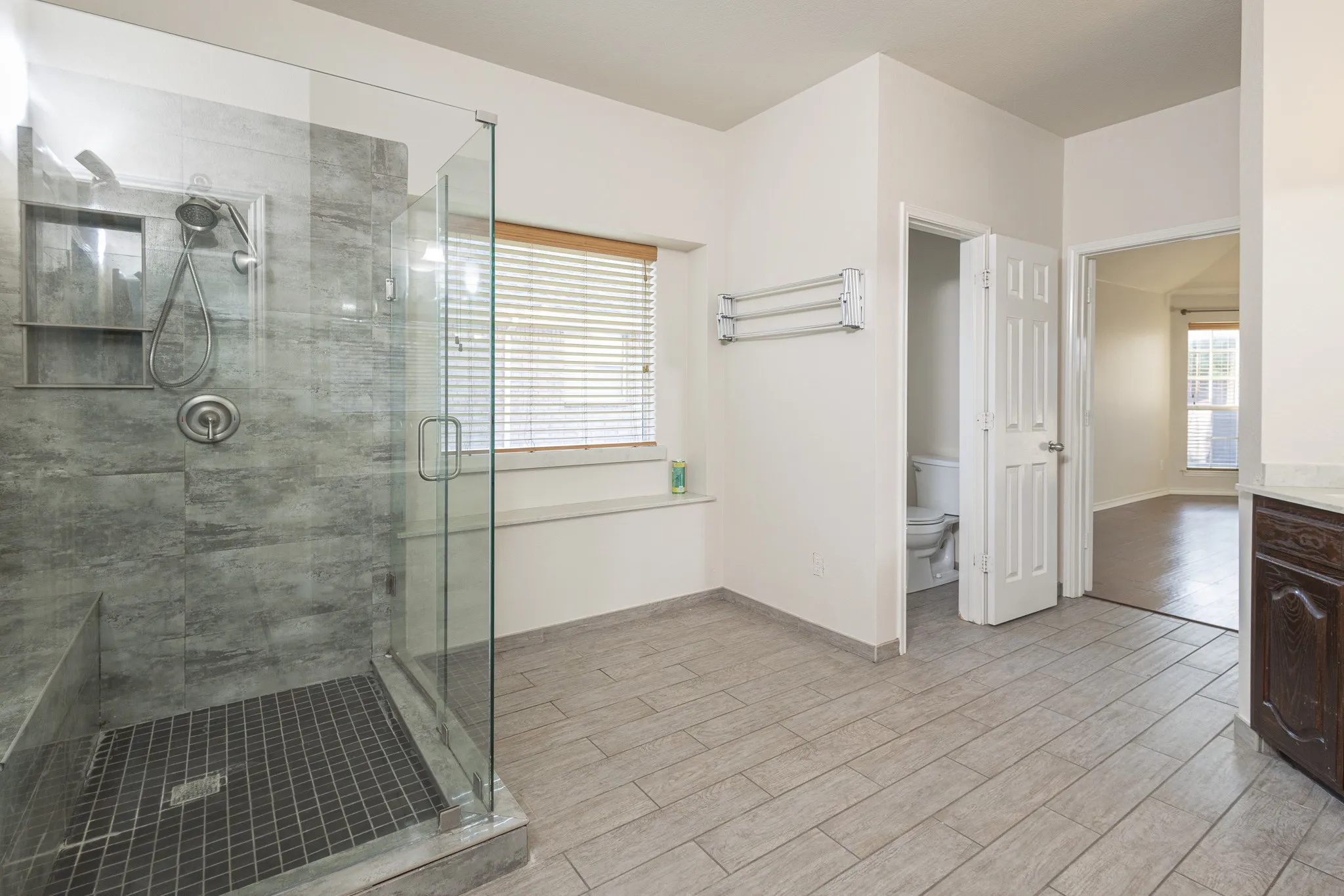 Bathroom with a shower with shower door, vanity, toilet, and hardwood / wood-style flooring