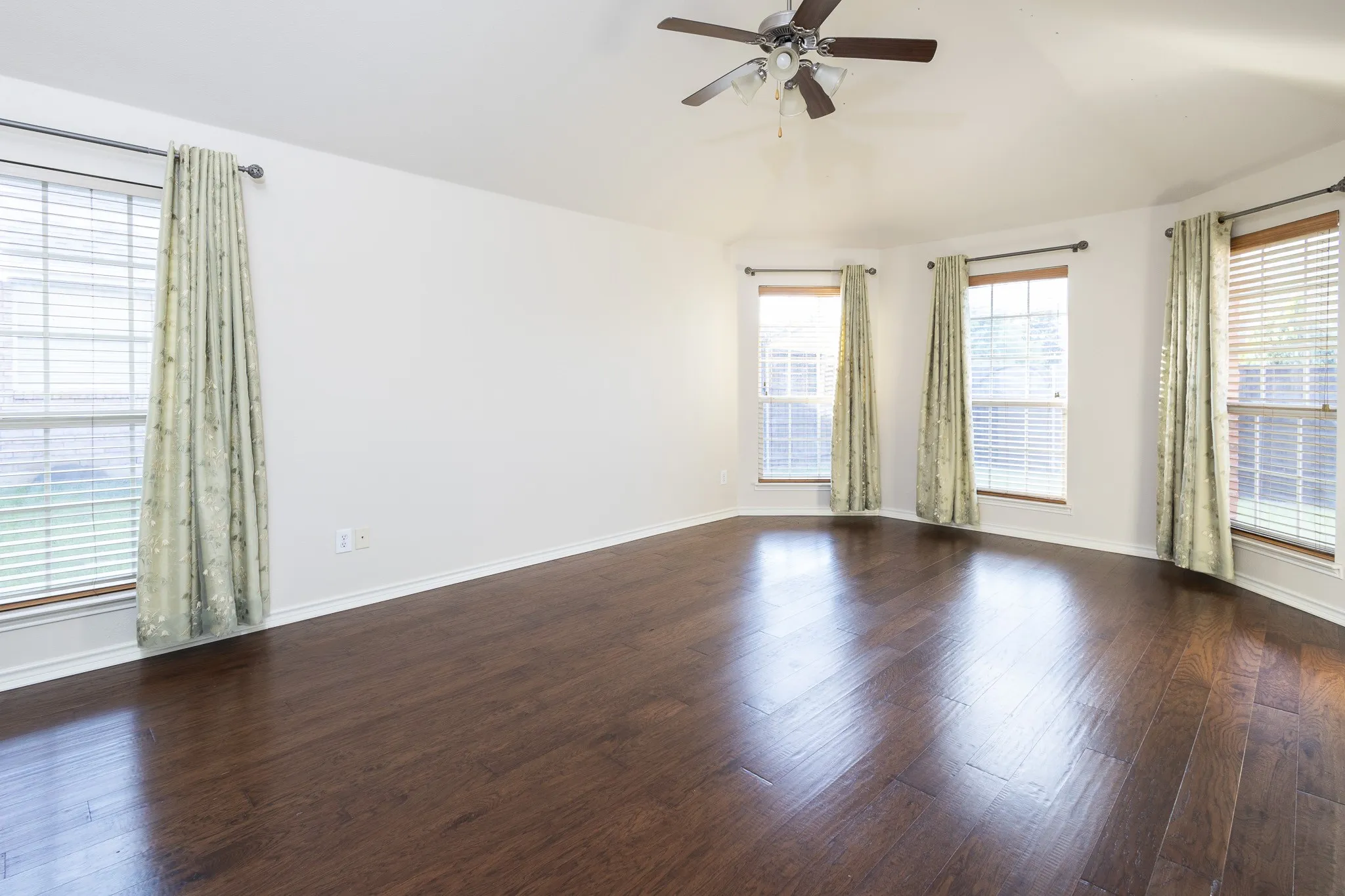 Unfurnished room with dark wood-type flooring and ceiling fan