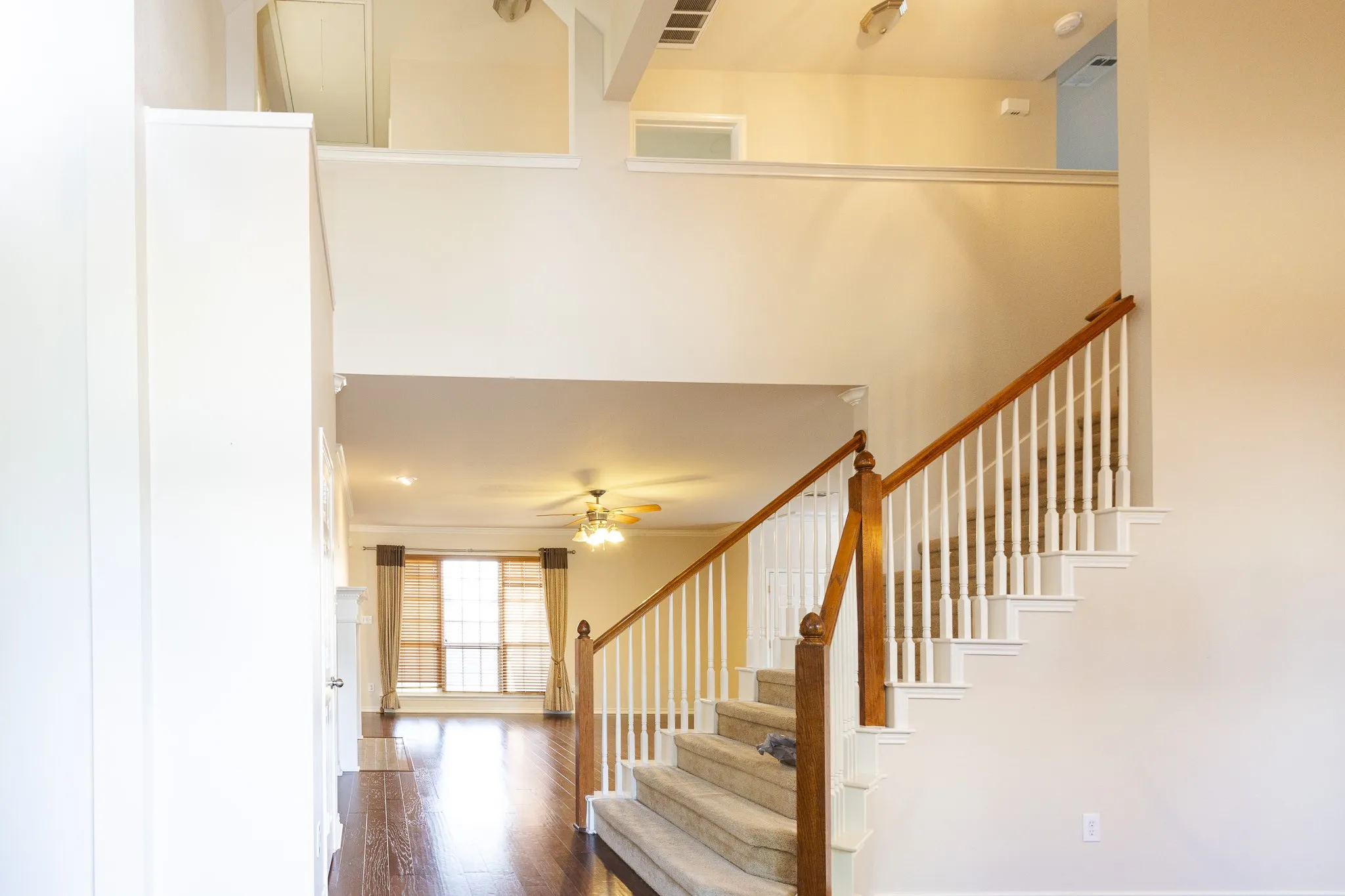 Stairway with dark hardwood / wood-style flooring, a high ceiling, and ceiling fan