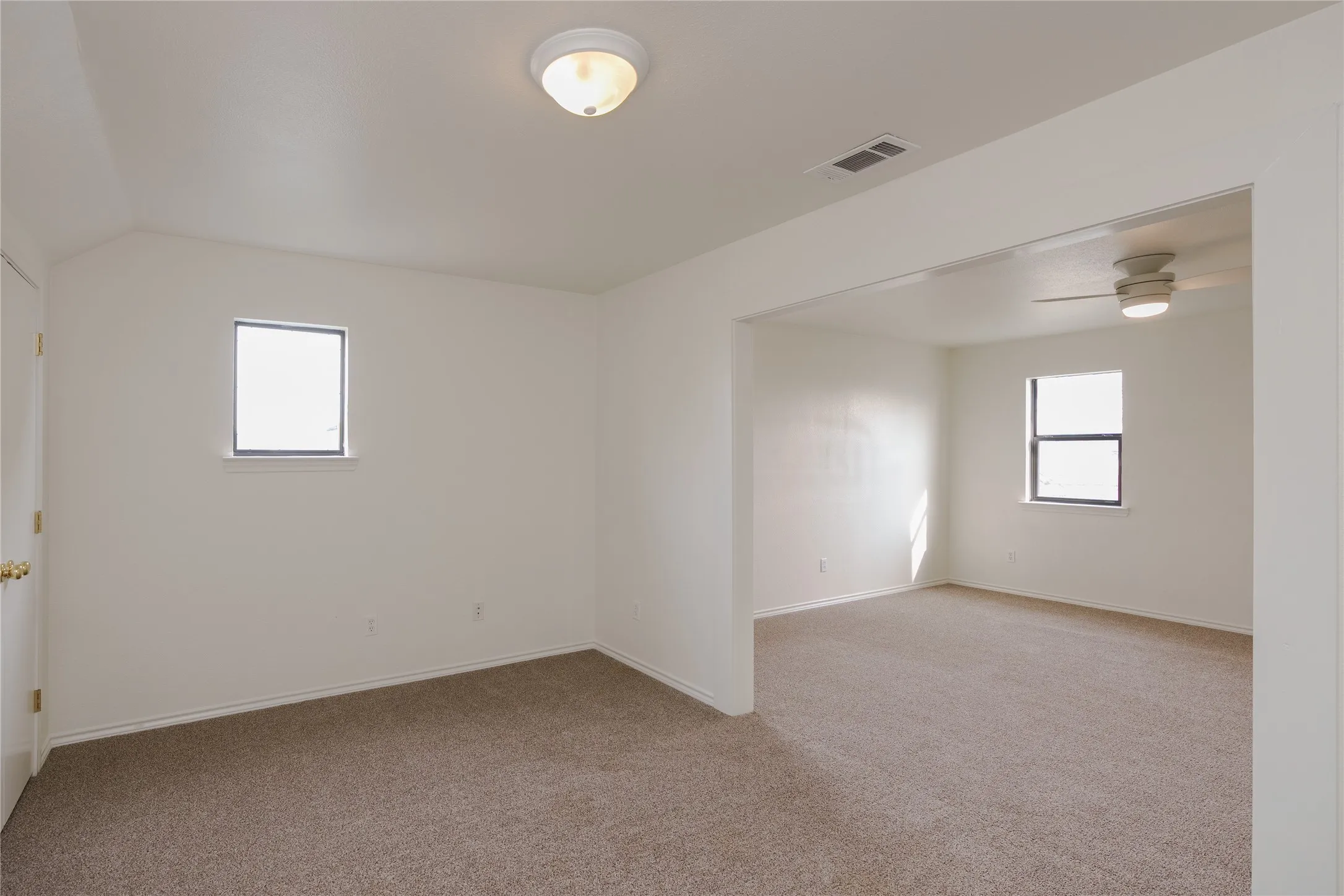 Upstairs second primary suite with Two distinct areas giving this bedroom a living suite as well as attached bathroom is great for multi generational living.l featuring neutral-toned carpeting and white walls