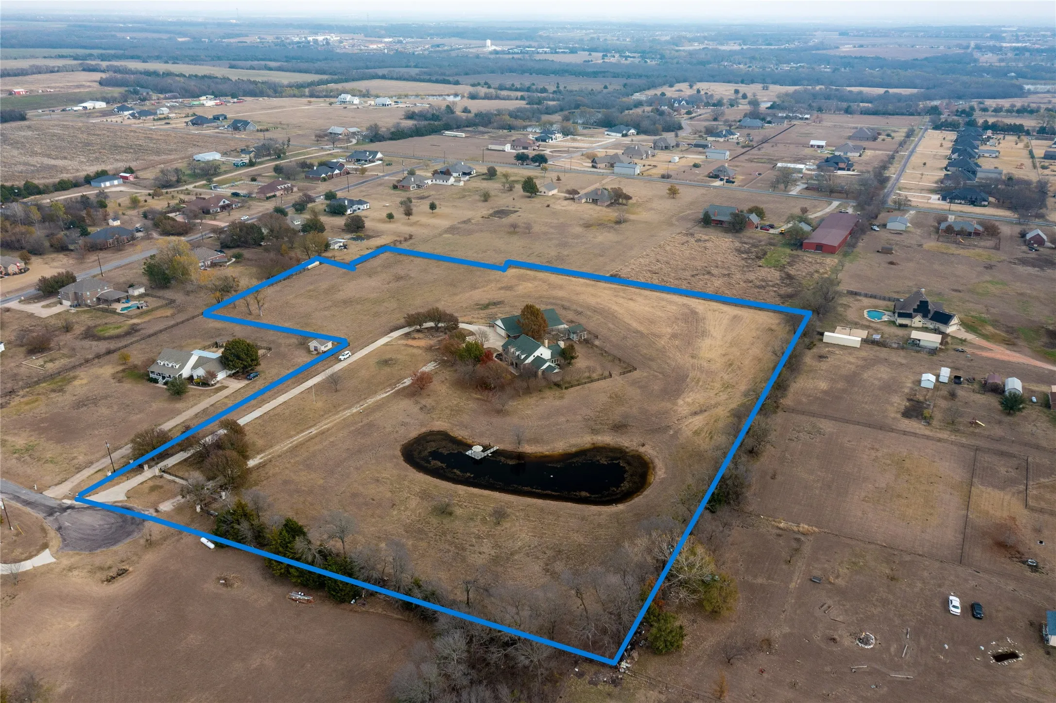 Expansive rural acreage featuring a large pond and mature trees