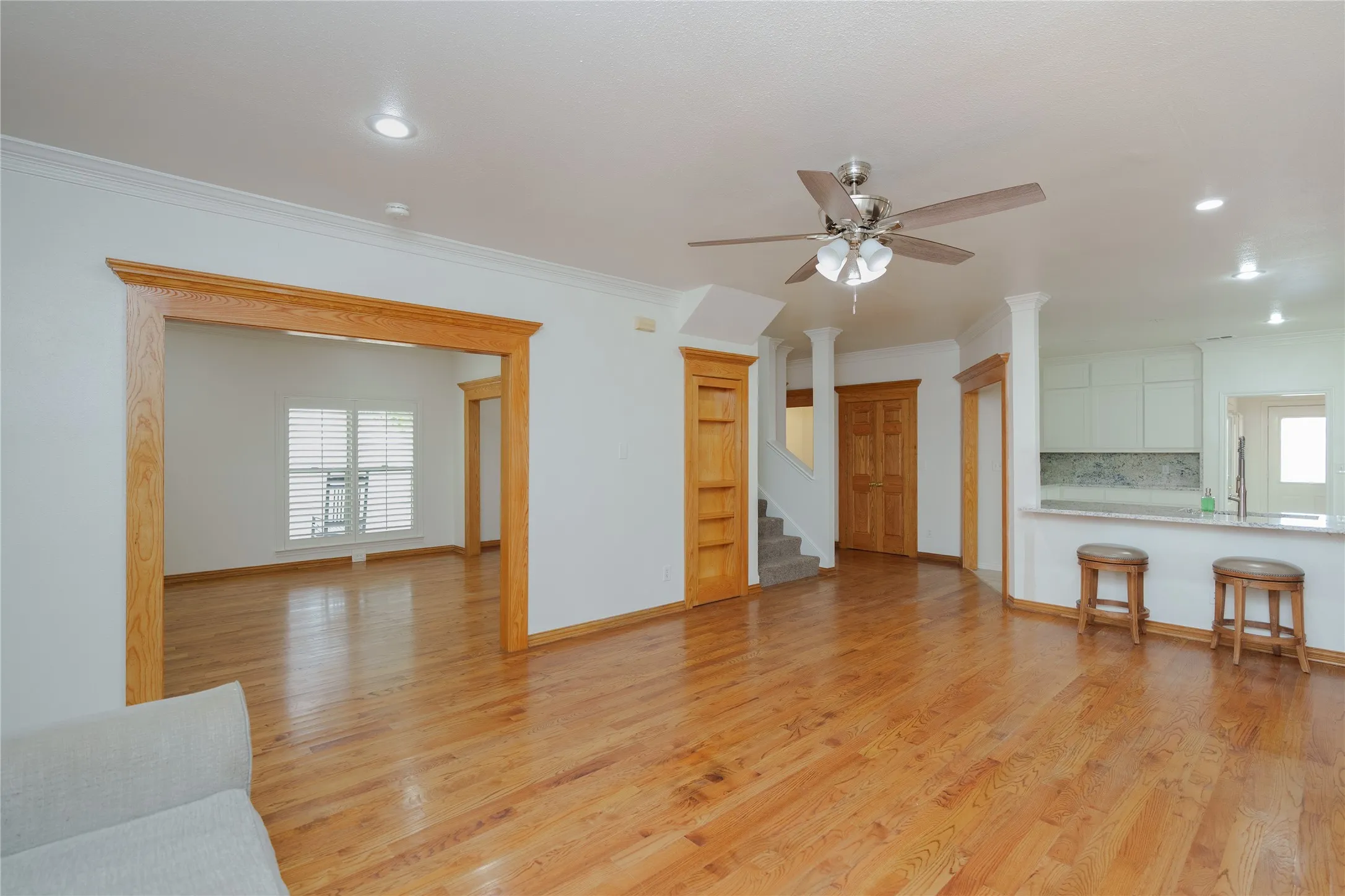 Spacious living area featuring wood-finish flooring, recessed lighting, and a ceiling fan