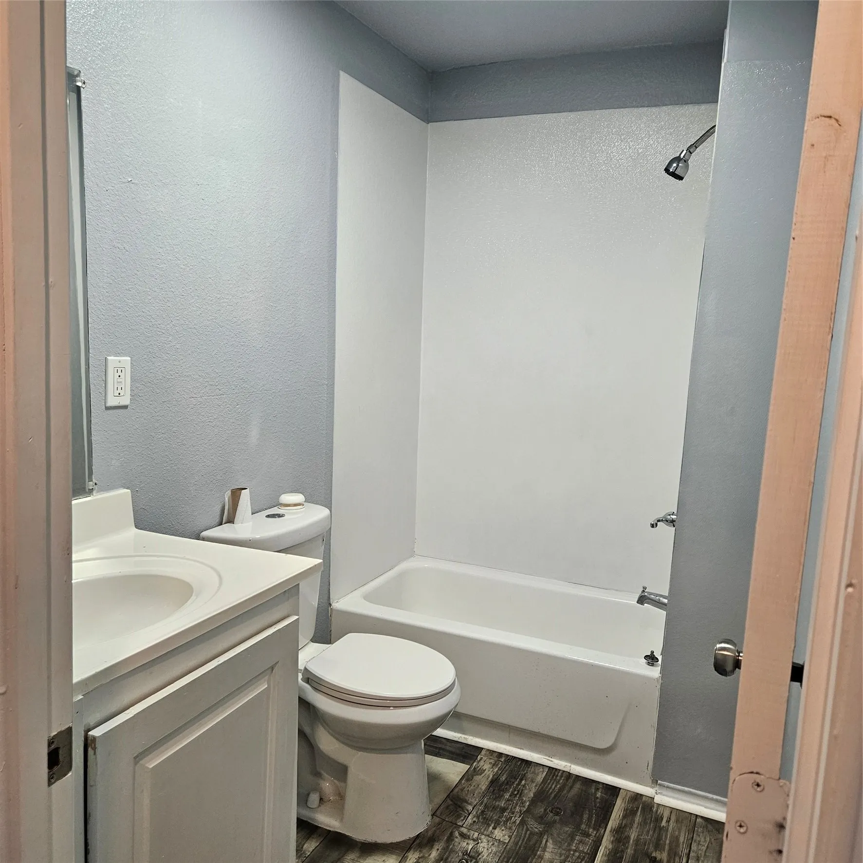 Full bathroom with a white vanity and integrated sink, toilet, and a tub/shower combination